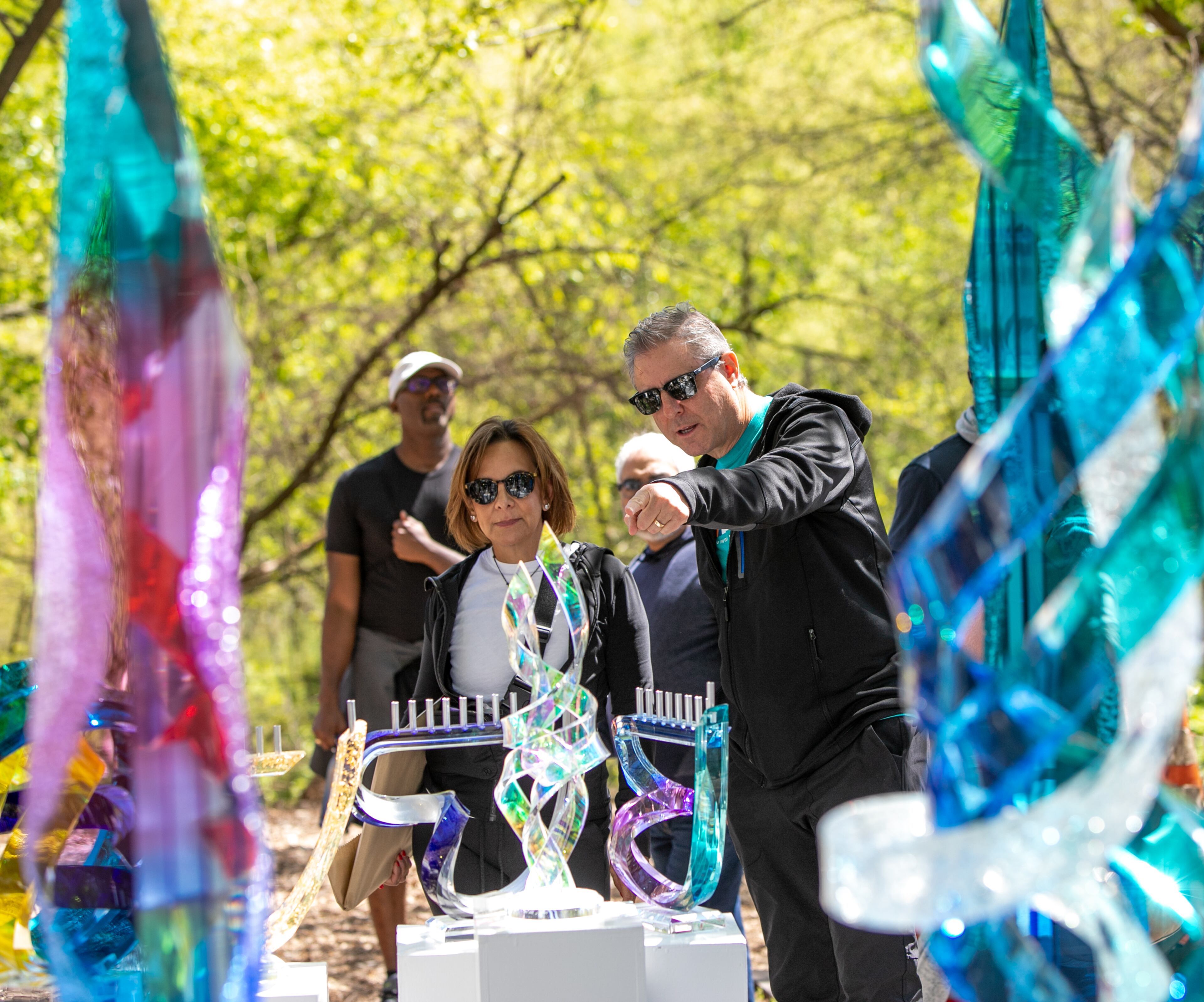 Nora, left, and Wayne Taylor, of East Cobb, spend time looking at acrylic and glass sculptures made by Will Grant at the 86th annual Atlanta Dogwood Festival in Piedmont Park on April 10, 2022. (Jenni Girtman for The Atlanta Journal-Constitution)