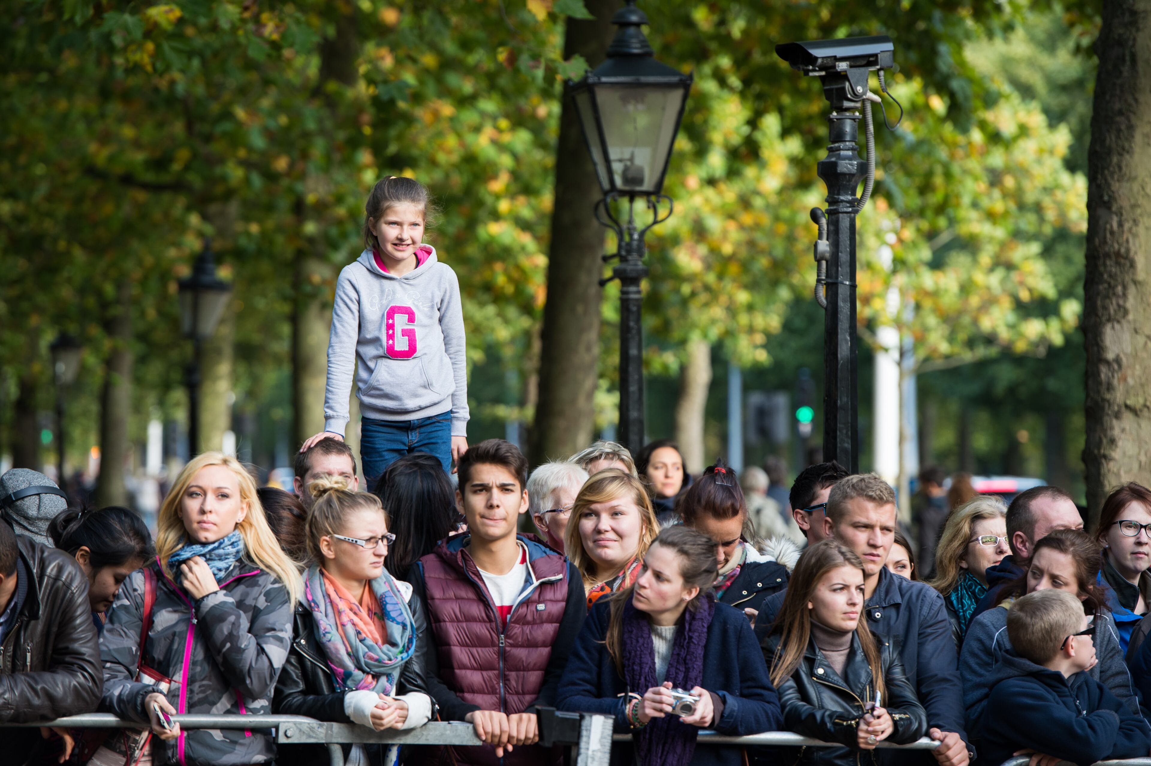 A crowd of onlookers gather to see the Royal Family arrive at St James's Palace on October 23, 2013 in London, England. (Photo by Ian Gavan/Getty Images)