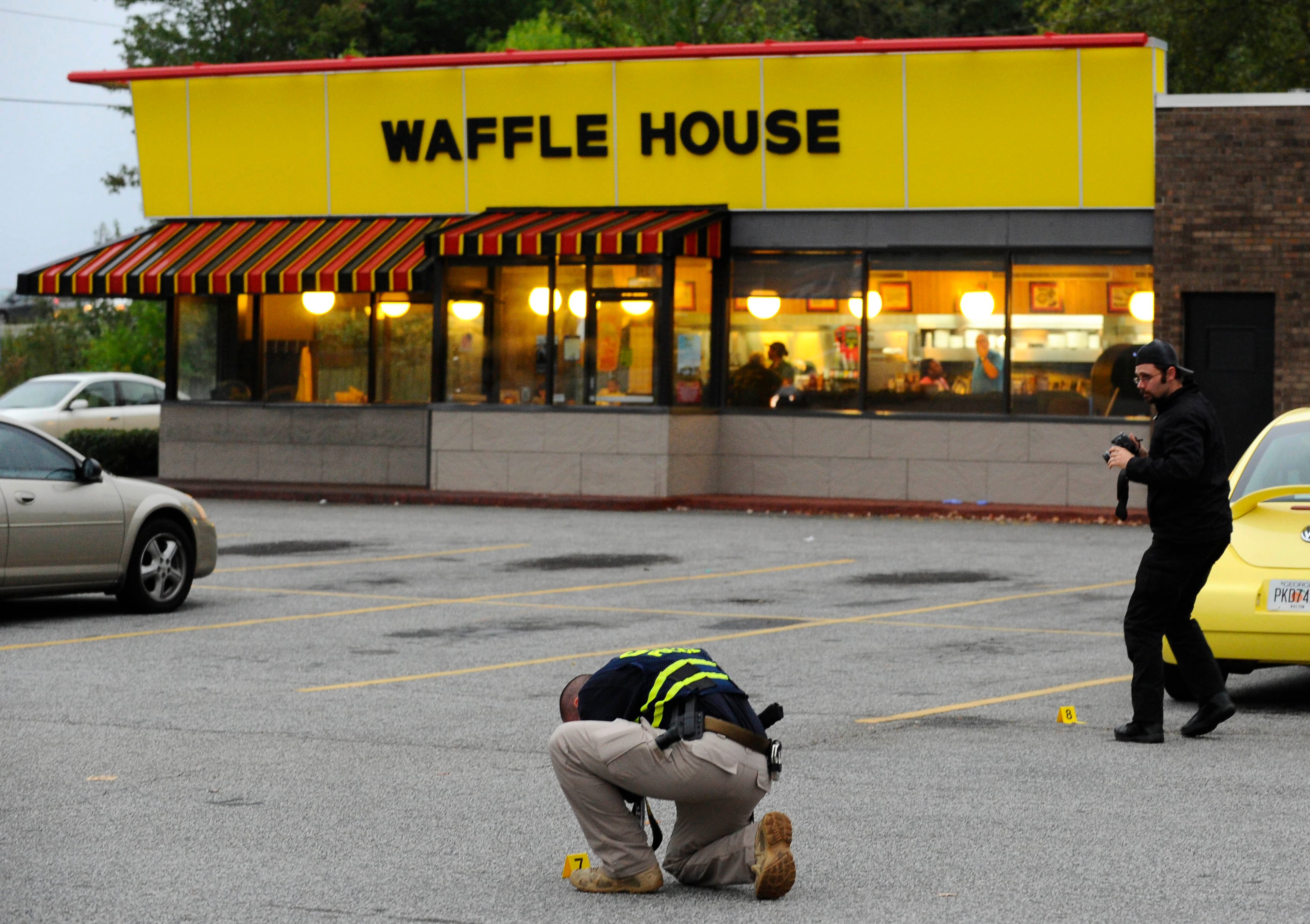 Norcross police and the GBI investigate an officer-involved shooting at the Fusion Event Hall parking lot next to a Knights Inn motel and the adjacent Waffle House at Indian Trail Road and Brook Hollow Parkway on Monday, Oct. 13, 2014, in Norcross, Ga.