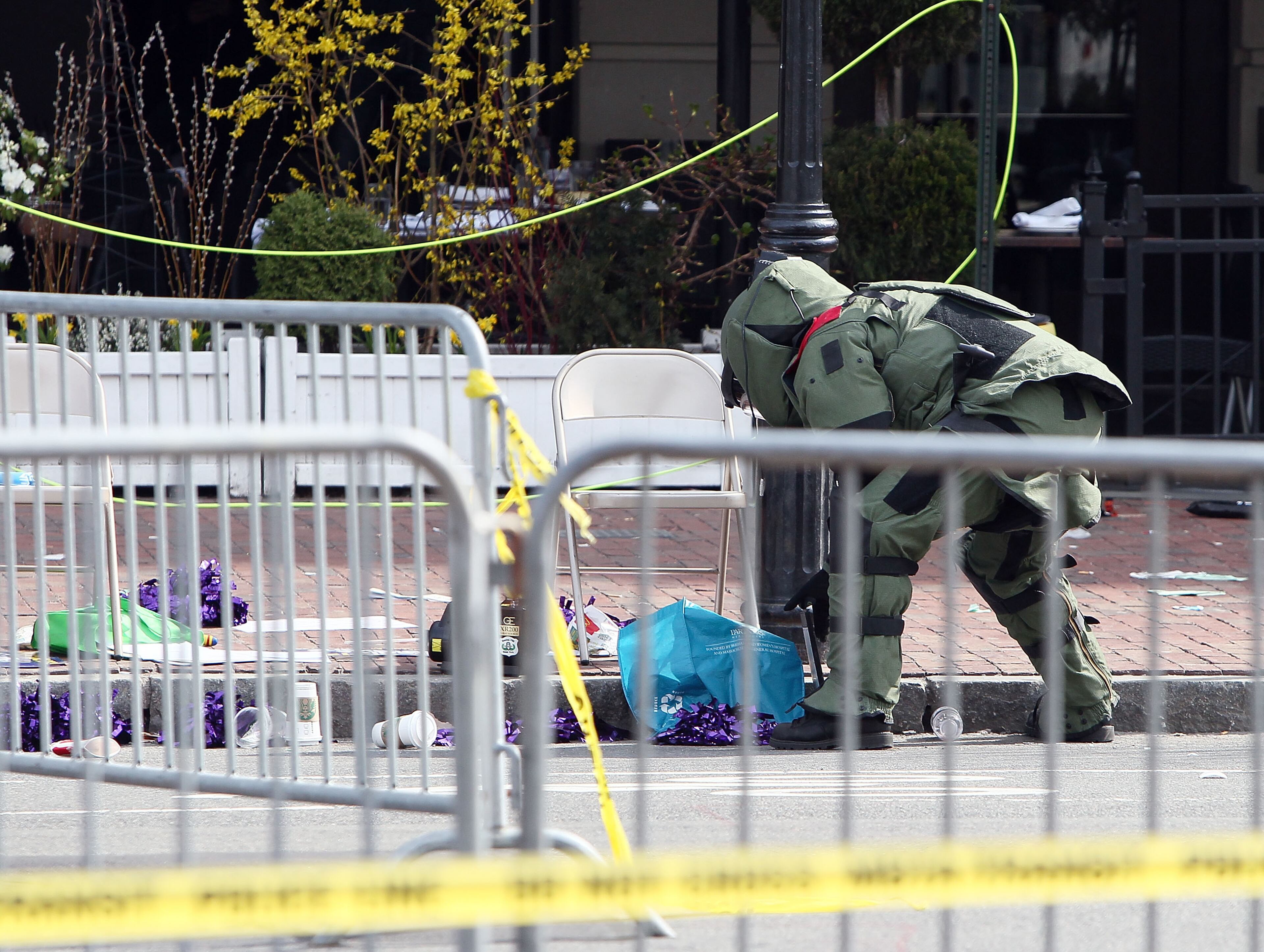 BOSTON, MA - APRIL 15: A member of the bomb squad investigates a suspicious item on the road near Kenmore Square after two bombs exploded during the 117th Boston Marathon on April 15, 2013 in Boston, Massachusetts. Two people are confirmed dead and at least 23 injured after two explosions went off near the finish line to the marathon. (Photo by Alex Trautwig/Getty Images)