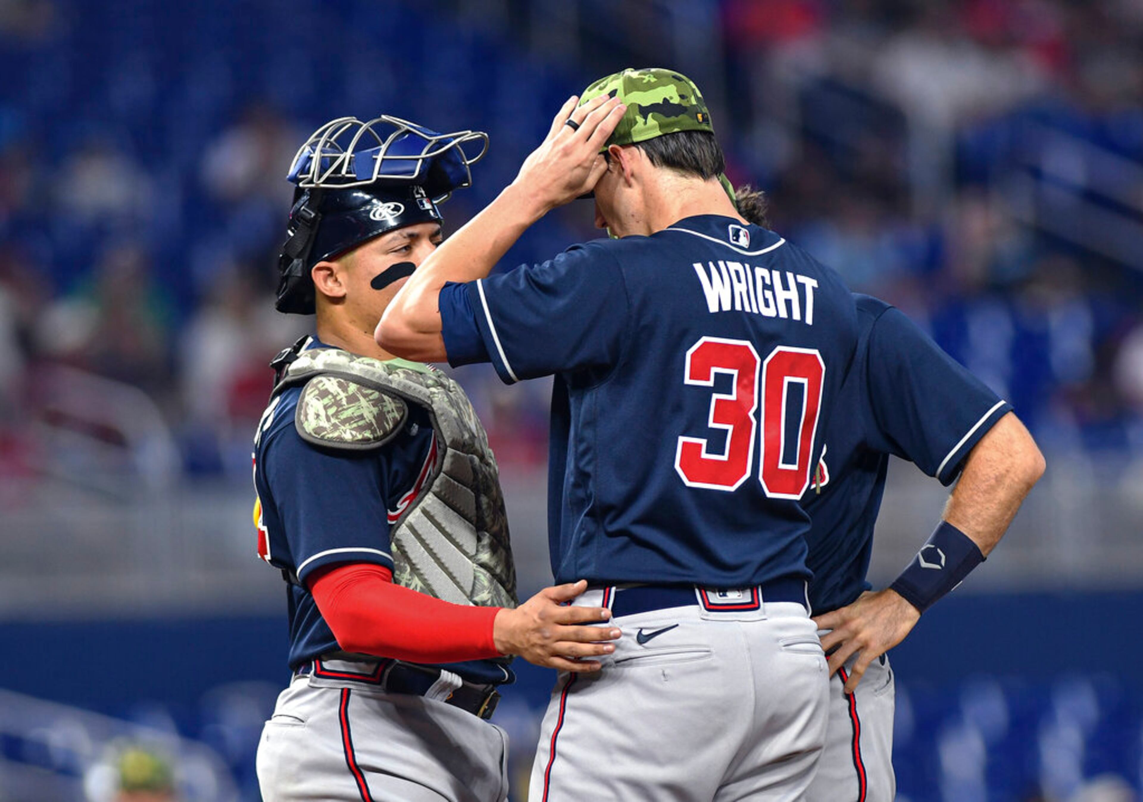 Atlanta Braves catcher Travis d'Arnaud, left, talks with starting pitcher Kyle Wright during the first inning of the team's baseball game against the Miami Marlins, Saturday May 21, 2022, in Miami. (AP Photo/Gaston De Cardenas)