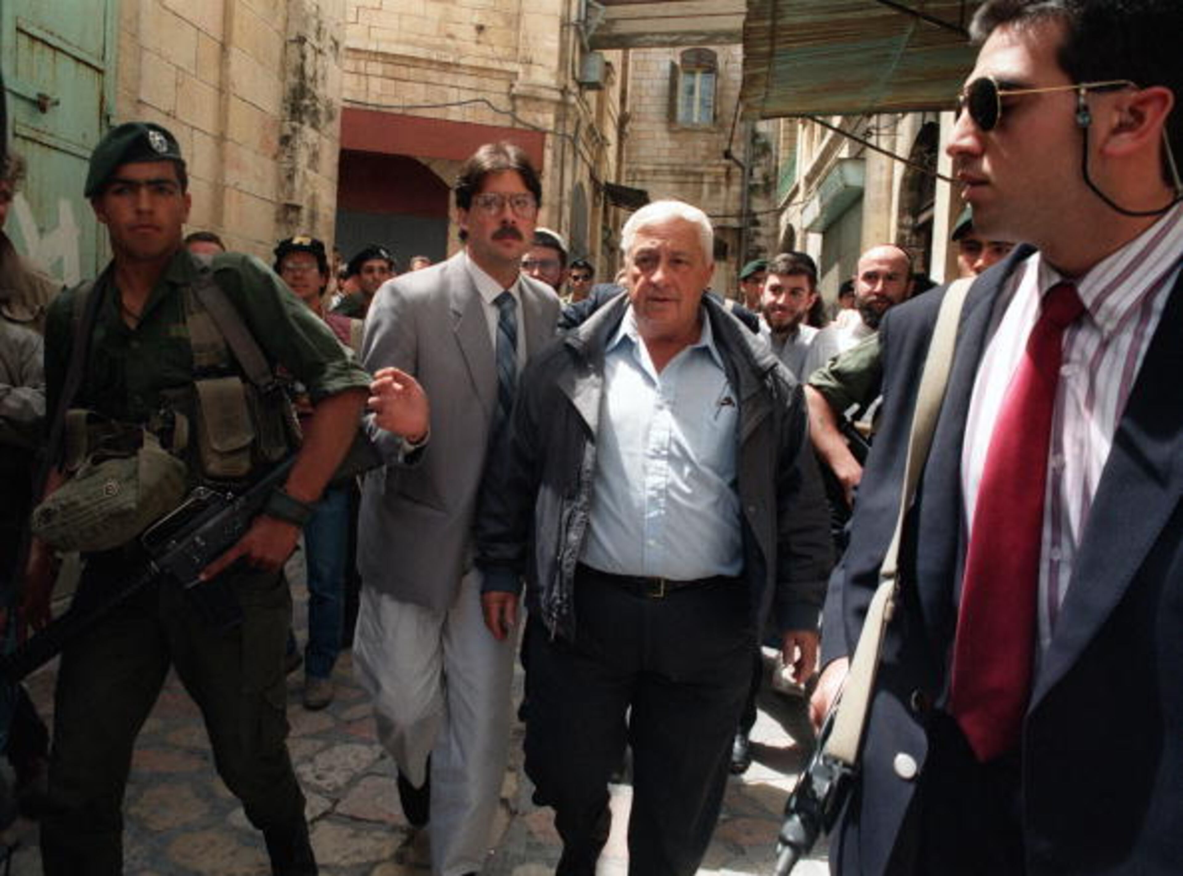 JERUSALEM:Likud leader Ariel Sharon (C) is escorted under heavy security to pay a visit to the new Jewish settlement in the disputed Greek Orthodox church-owned building in Jerusalem's Old City 13 April 1990. AFP PHOTO PATRICK BAZ (Photo credit should read PATRICK BAZ/AFP/Getty Images)