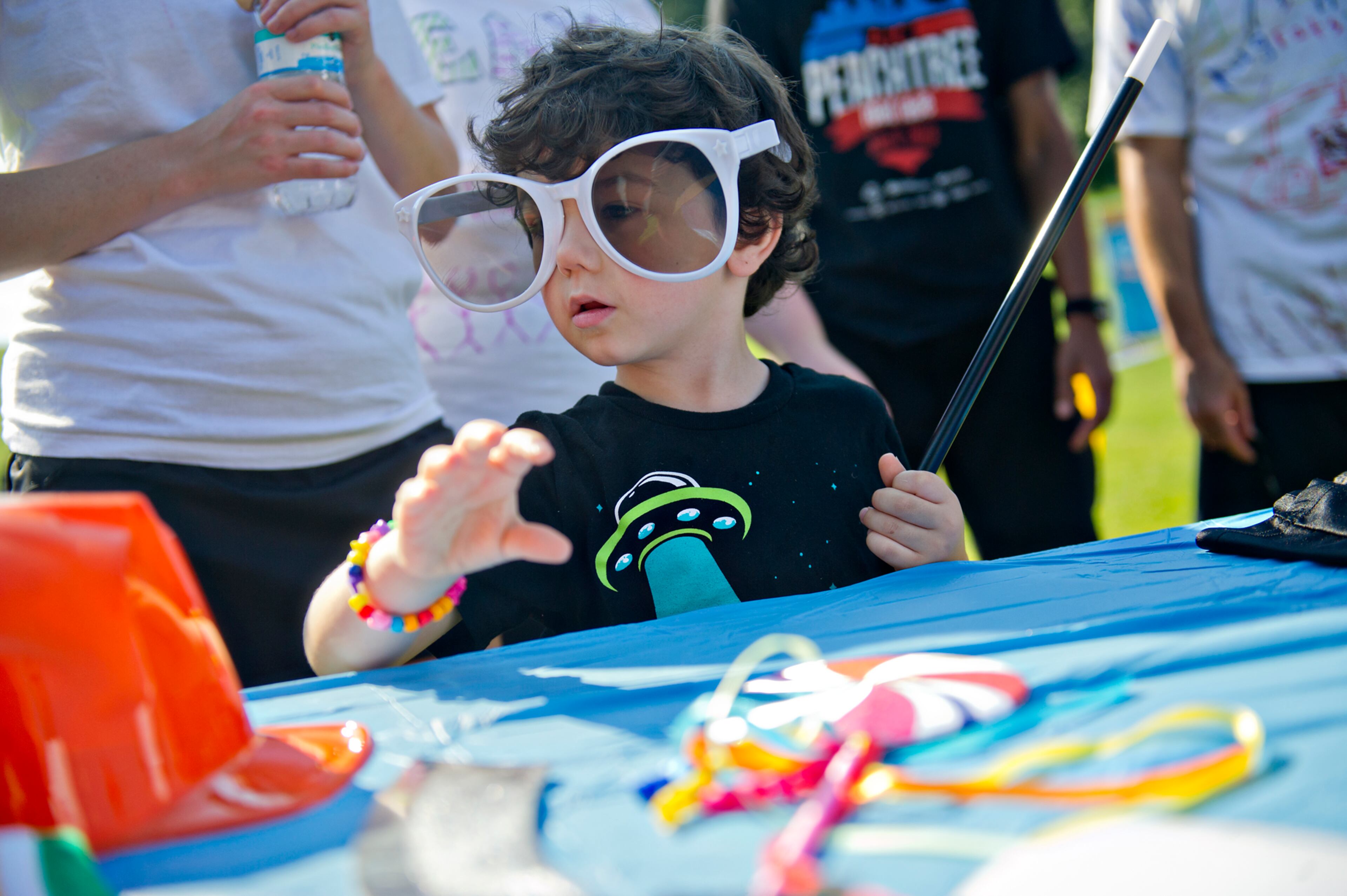 Isaac Guessous (center) decides on a costume during the Boys & Girls Clubs of America's Day for Kids at Piedmont Park in Atlanta on Saturday, September 7, 2013. Day for Kids is a national initiative to raise awareness for critical issues facing young men and women. With more than a decade of tradition, Day for Kids invites adults to act like kids again by participating in field day events such as relay races, dodge ball, tug of war and lots of other activities. JONATHAN PHILLIPS / SPECIAL