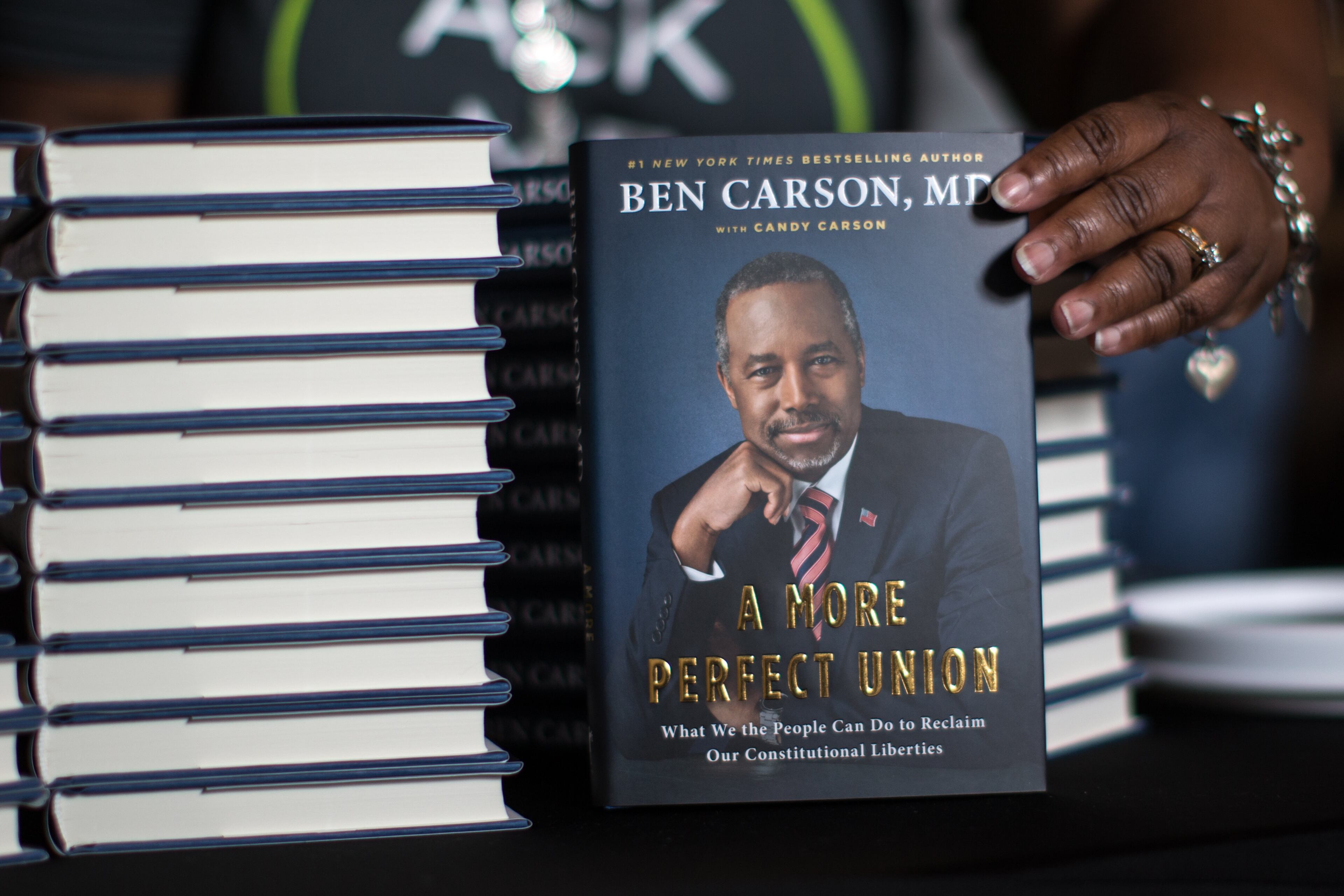 Pam Welchel places a copy of Republican presidential candidate Dr. Ben Carson's book "A More Perfect Union: What We the People Can Do to Reclaim Our Constitutional Liberties" on a table at Free Chapel, Sunday, Oct. 11, 2015, in Gainesville, Ga. Carson promoted the book that he co-authored with his wife Candy Carson during his visit to the church. BRANDEN CAMP/SPECIAL