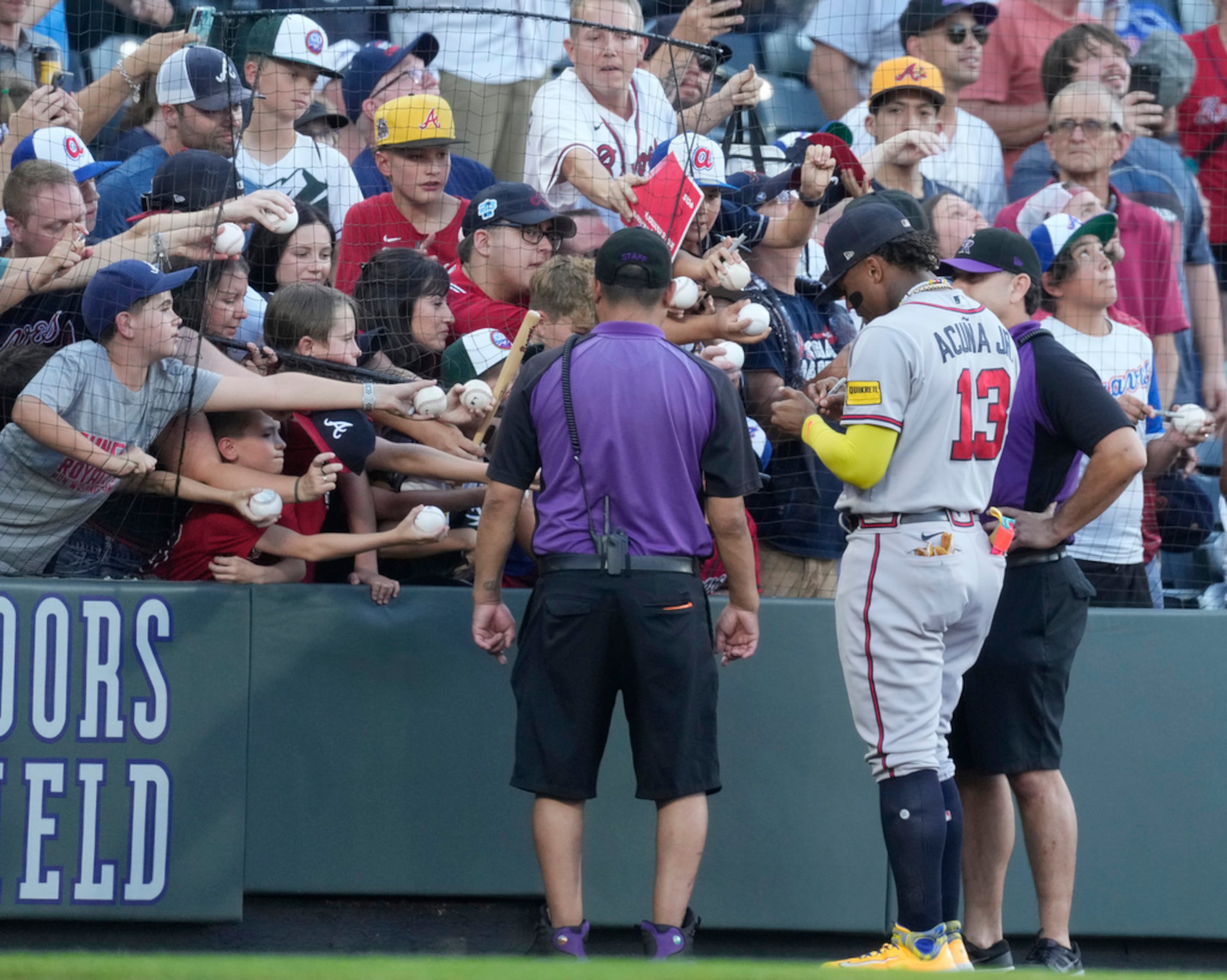 Atlanta Braves right fielder Ronald Acuna Jr. (13) signs autographs for fans before the team's baseball game against the Colorado Rockies on Wednesday, Aug. 30, 2023, in Denver. (AP Photo/David Zalubowski)