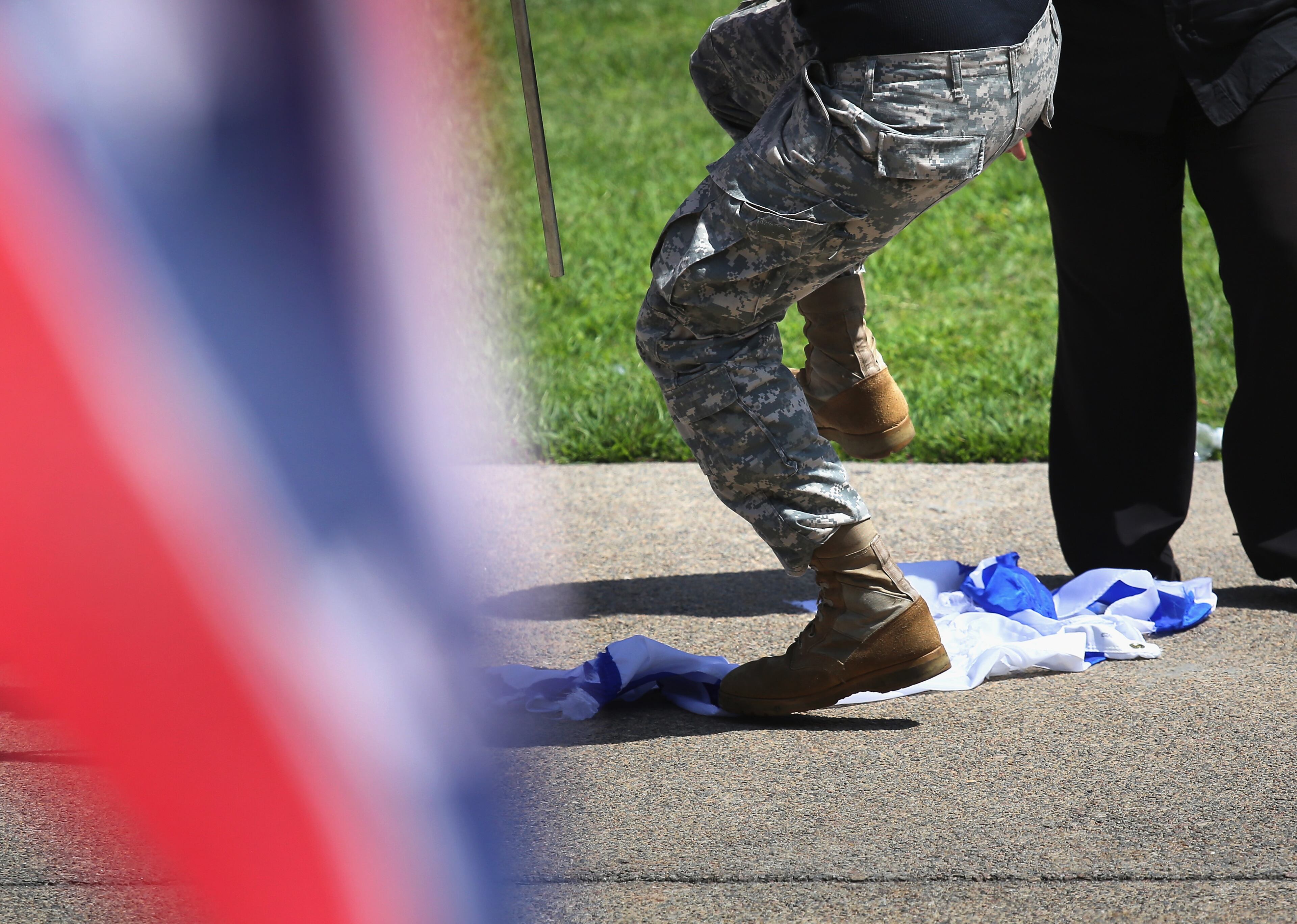 COLUMBIA, SC - JULY 18: A Neo Nazi stomps on an Israeli flag after ripping it up at a Ku Klux Klan demonstration at the state house building on July 18, 2015 in Columbia, South Carolina. The KKK protested the removal of the Confederate flag from the state house grounds and hurled racial slurs at minorities as law enforcement tried to prevent violence between the opposing groups. (Photo by John Moore/Getty Images)