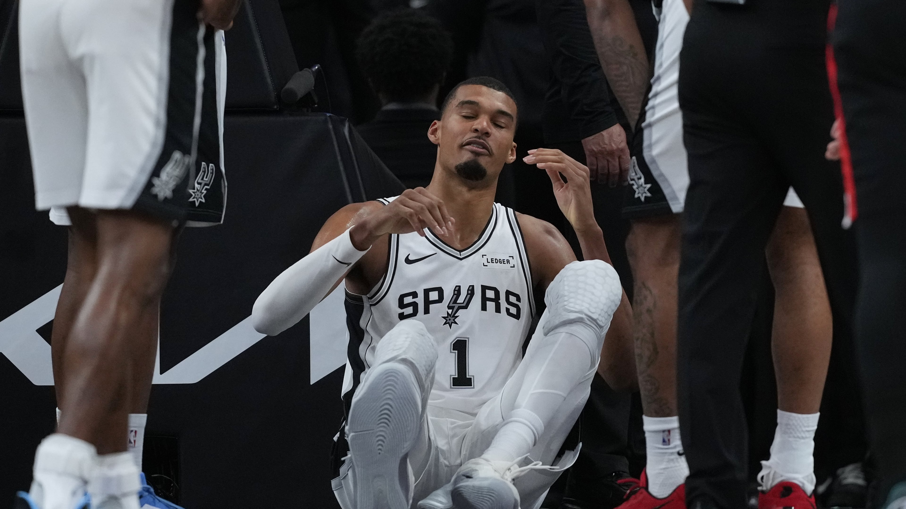 San Antonio Spurs forward Victor Wembanyama (1) sits on the court after a hard fall during the first half in Game 2 of a first-round NBA playoffs basketball series against the Portland Trail Blazers in San Antonio, Tuesday, April 21, 2026. (AP Photo/Eric Gay)
