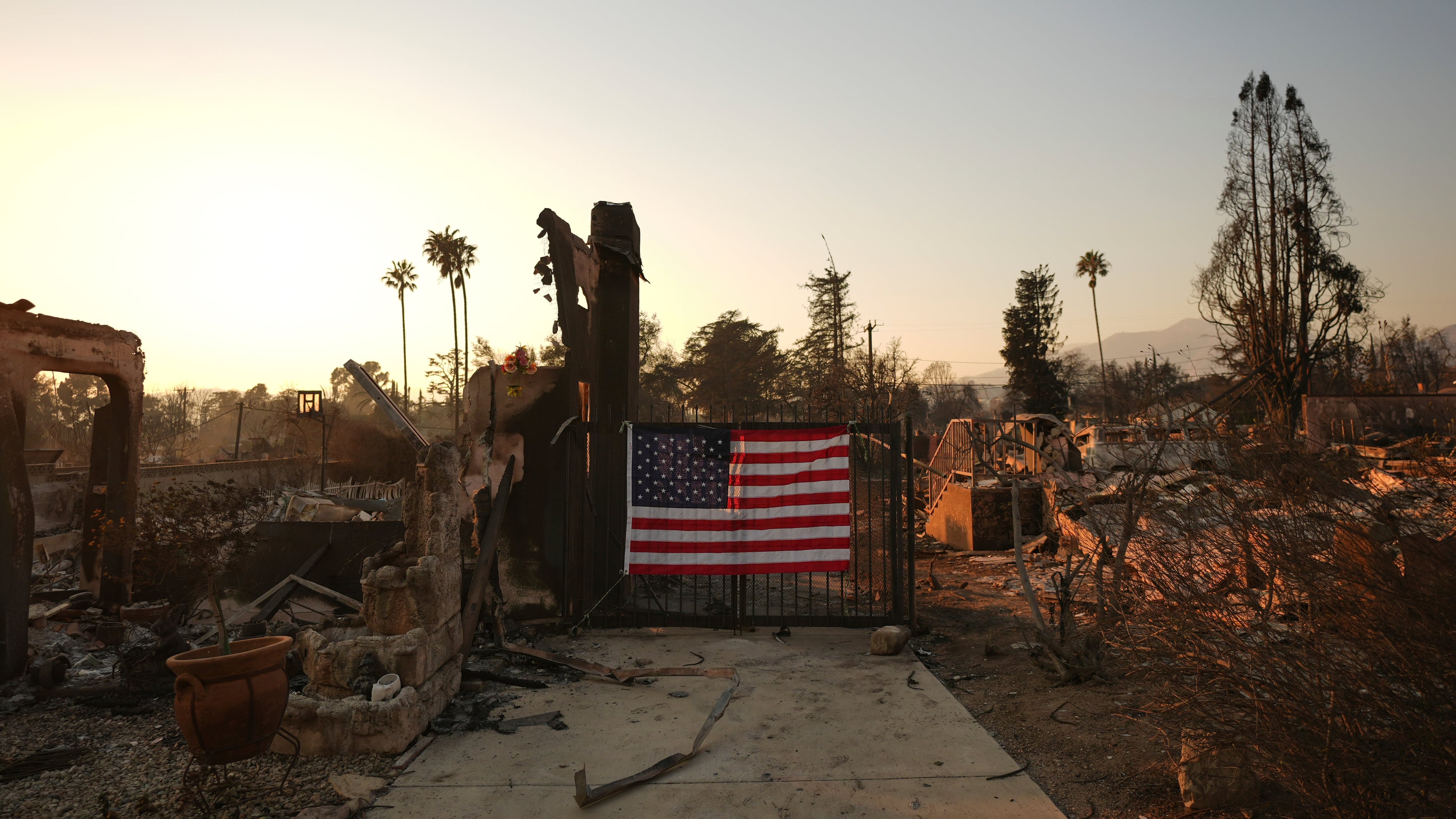 FILE - An American flag hangs on the gate of a home destroyed by the Eaton Fire in Altadena, Calif., Jan. 10, 2025. (AP Photo/Jae C. Hong, File)