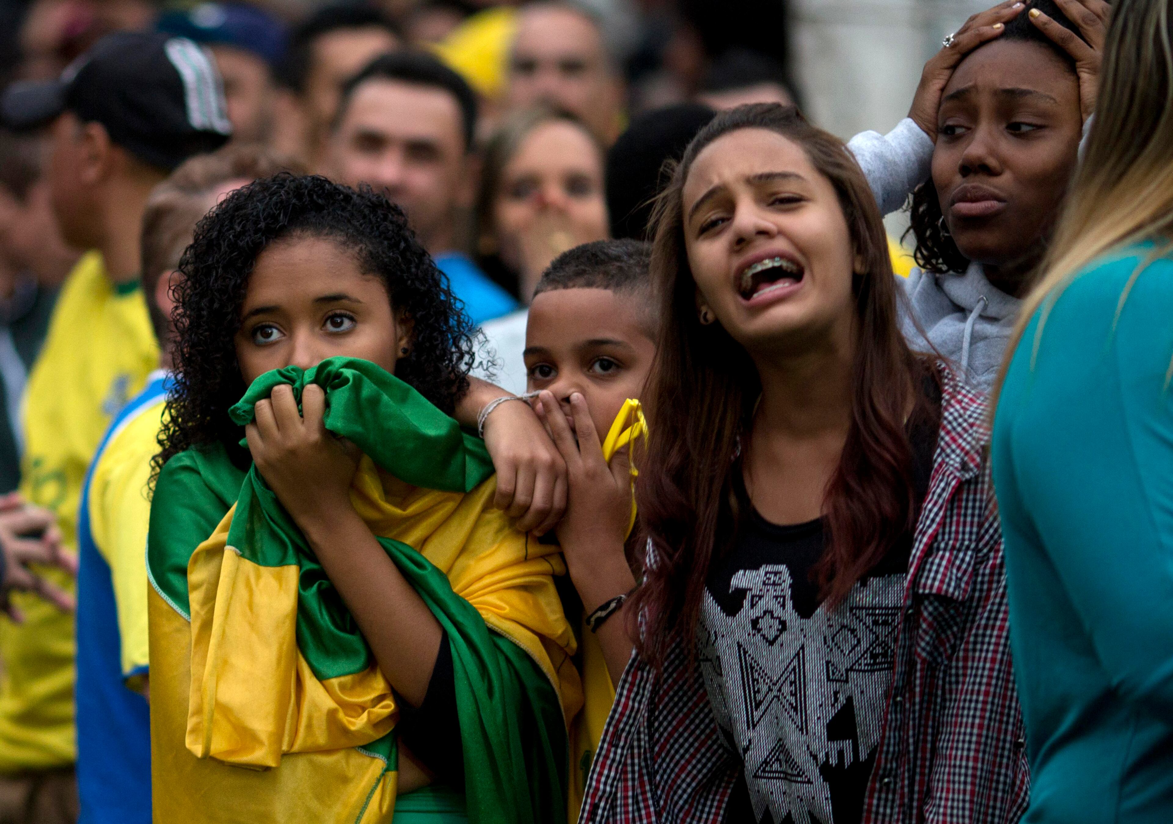Brazil soccer fans watch their team lose to Germany at a World Cup semifinal game on TV in Sao Paulo, Brazil, Tuesday, July 8, 2014. (AP Photo/Rodrigo Abd)