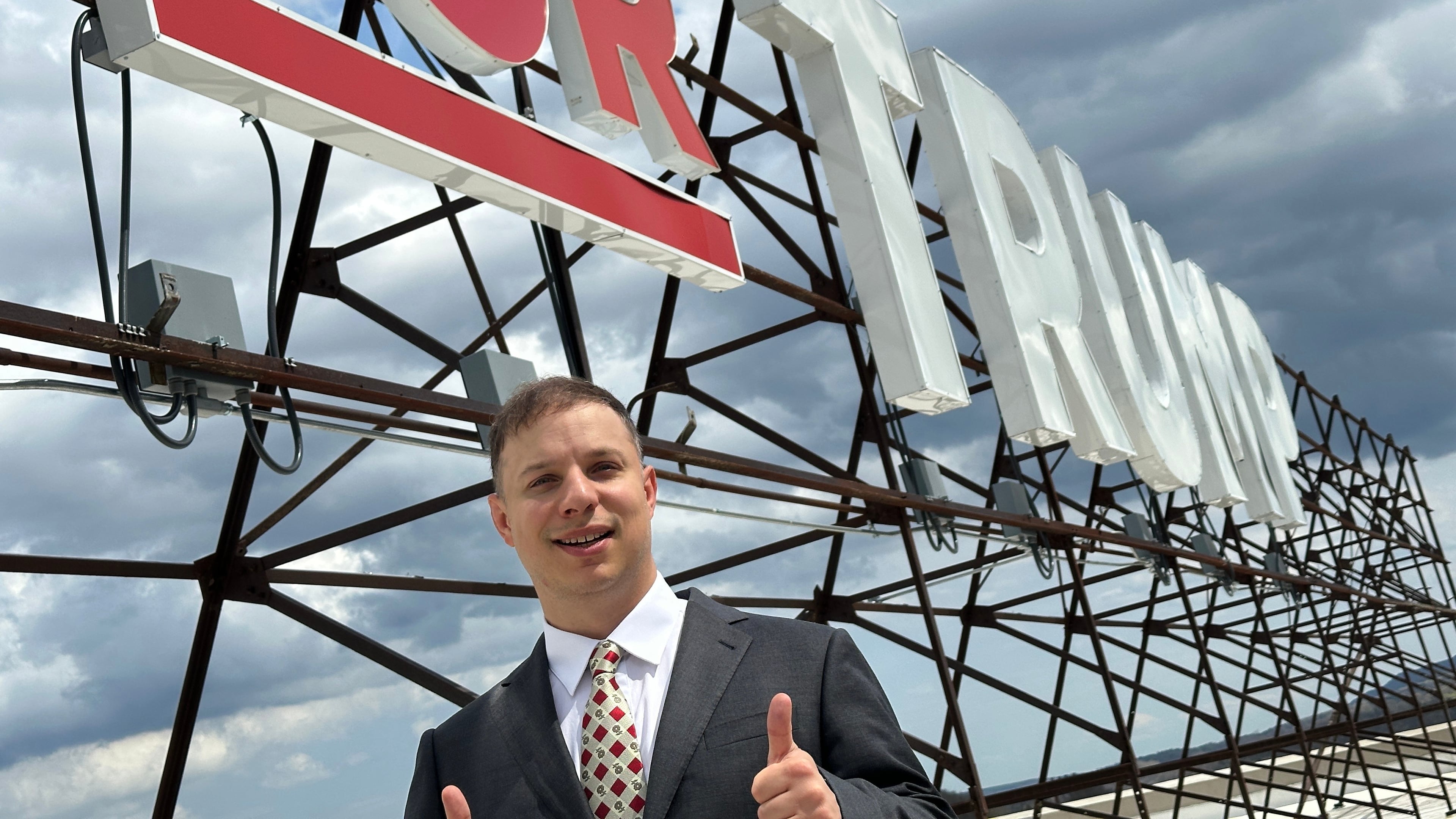Anthony Constantino, a Republican candidate for Congress, stands next to the large "Vote for Trump" sign on the roof of his printing company, Sticker Mule, in Amsterdam, New York, Thursday, April 16, 2026. (AP Photo/Michael Hill)