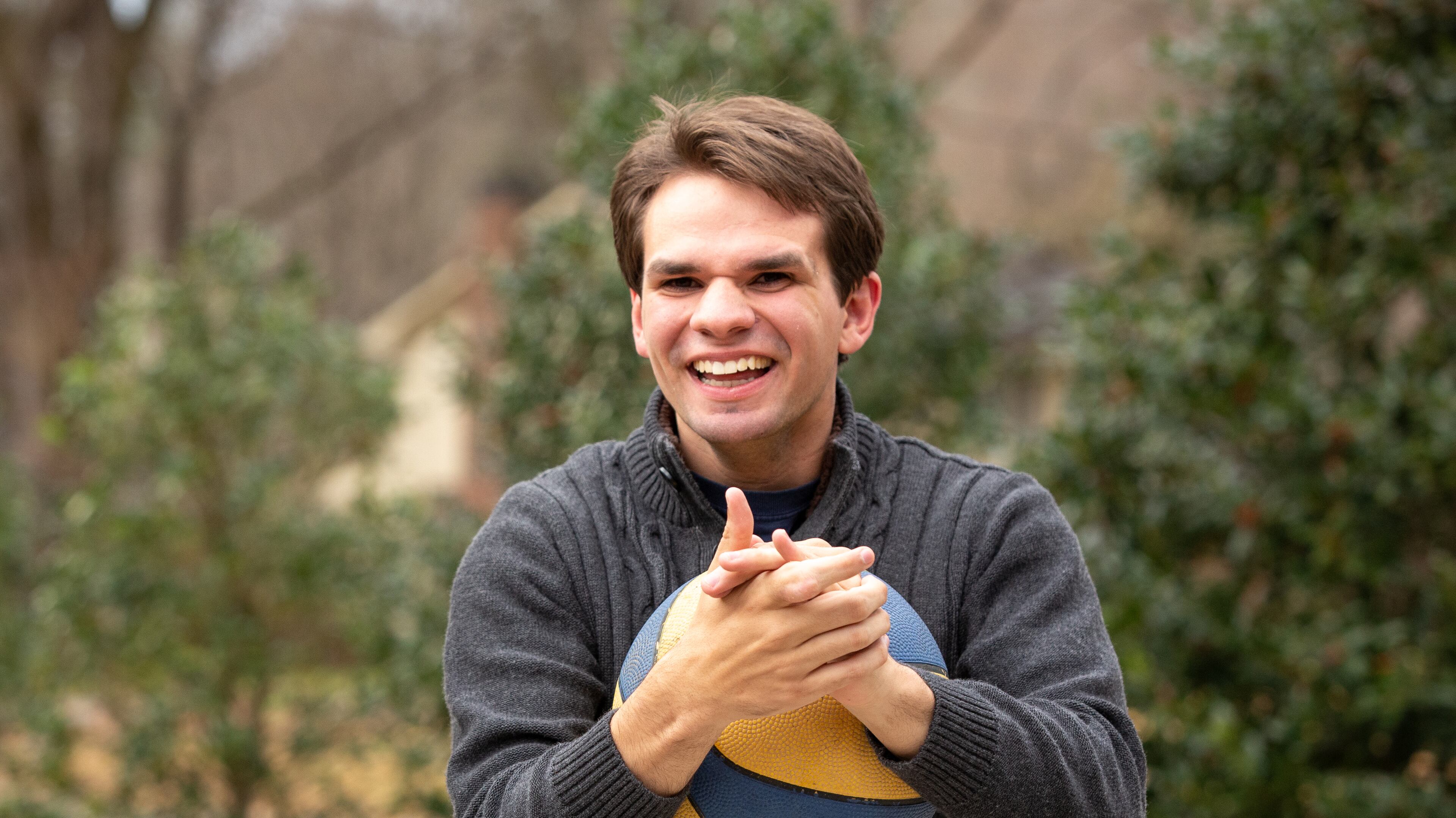 Evan Woody, 21, laughs as he plays basketball in the driveway of his home in Dunwoody, Ga. on Wednesday, Dec. 23, 2020. Evan is mentally and physically disabled as a result of a traumatic brain injury that occurred when he was a toddler. According to his parents, Phil and Lisa Woody, Evan has the mental equivalency of a three-year-old and is nonverbal. Since the start of the pandemic, Evan has undergone virtual learning for school, which his parents, Phil and Lisa Woody, say is ineffective. The Woodys say that Evan's hours of instruction have decreased from about 35 hours per week for normal in-person school to about 6.5 hours per week for virtual school, only 2 of which are one-on-one. Furthermore, he requires constant attention and supervision, which has been difficult for Phil and Lisa, who are both working full-time from home. They have estimated that they will need to save $2.8 million in order to provide for Evan throughout his life. While Evan has been approved for a Medicaid program (NOW/COMP Waiver), his parents say the program has never been fully funded by the state of Georgia, and Evan, with thousands of other disabled Georgians, will remain on the waitlist indefinitely. (Casey Sykes for The Atlanta Journal-Constitution)