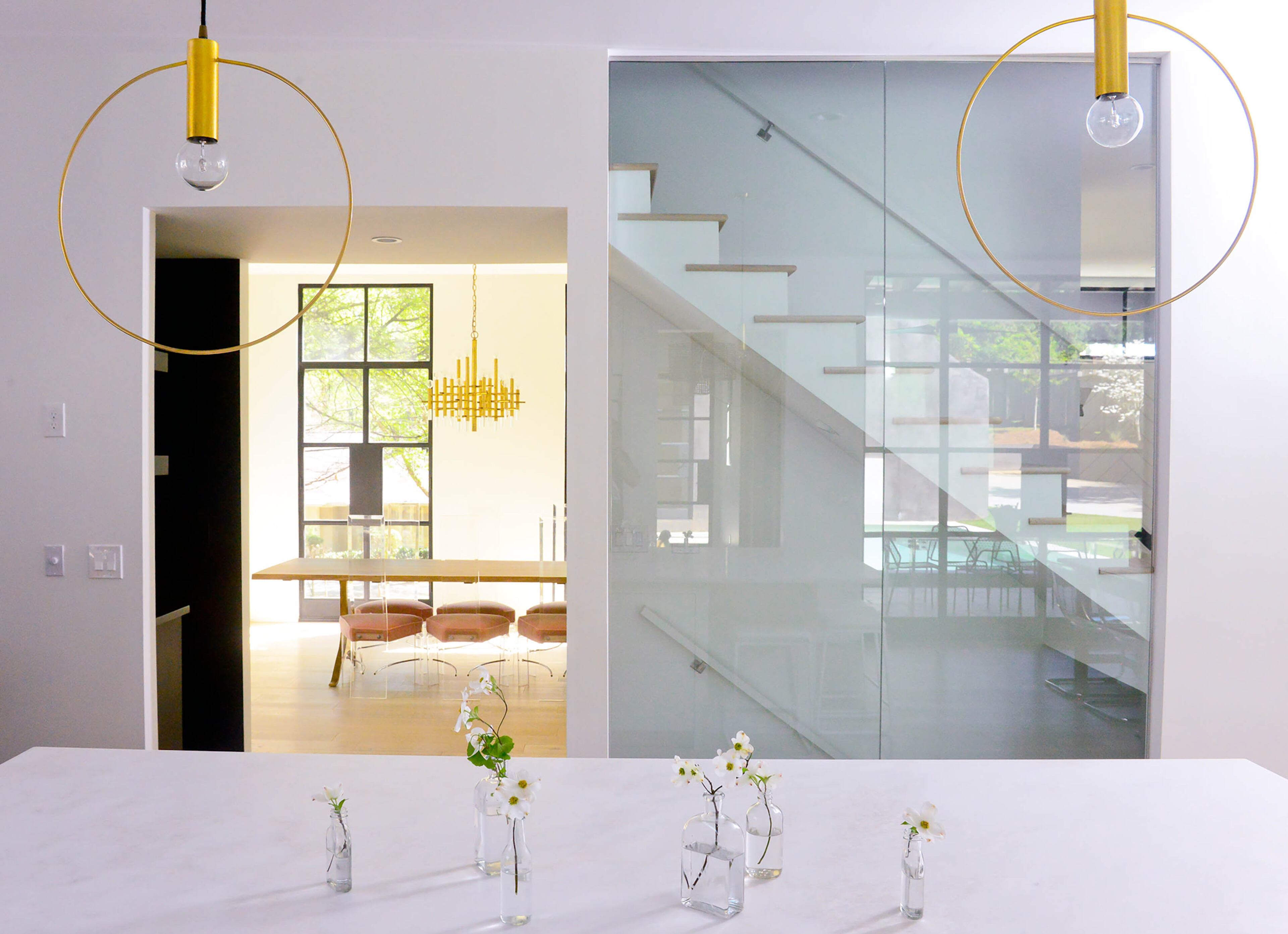 Pendant lighting from Etsy illuminates the Namibia White marble countertops on the kitchen island.