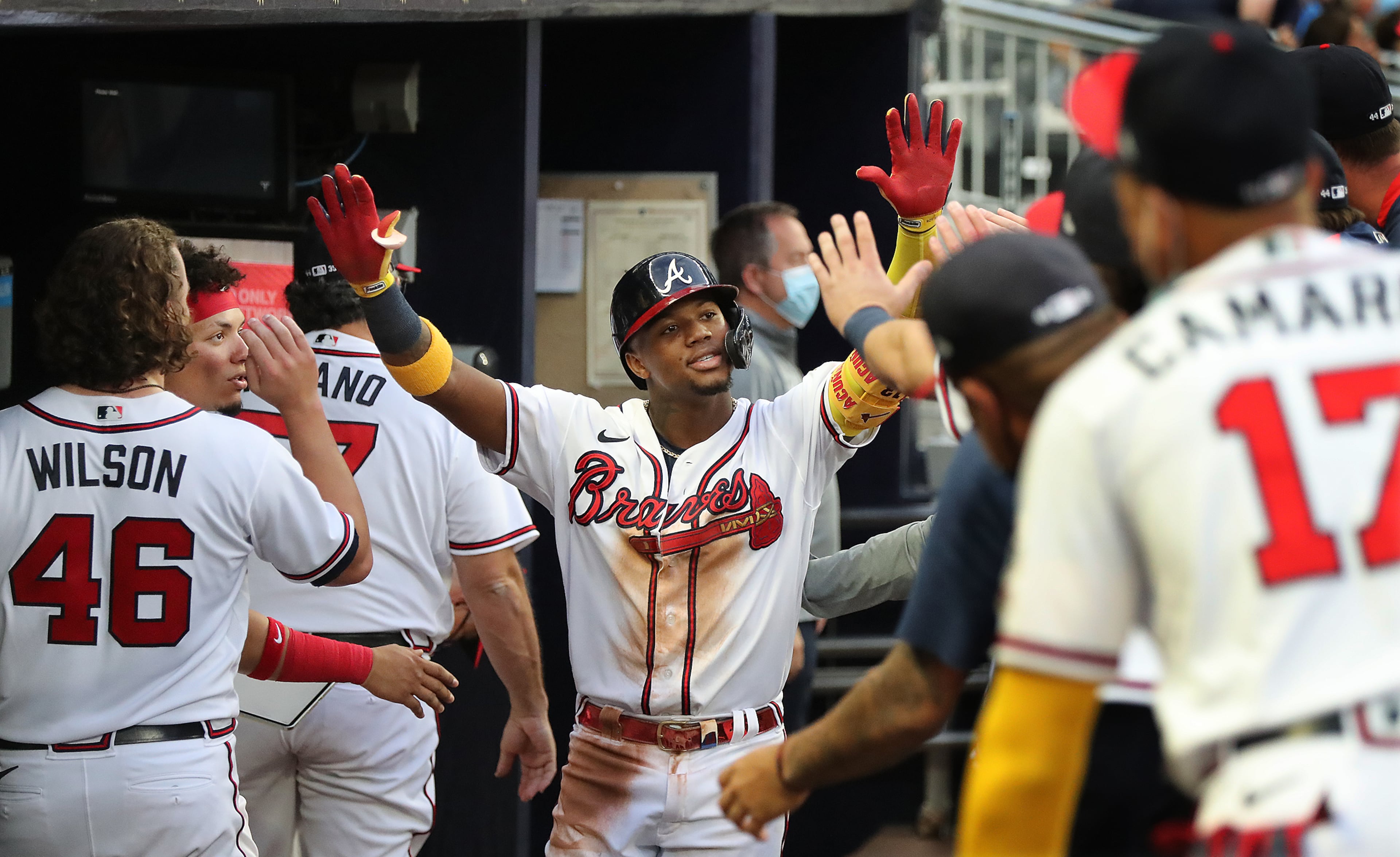 Braves outfielder Ronald Acuna gets high fives in the dugout after hitting a solo home run to take a 2-0 lead over the Toronto Blue Jays during the third inning in a MLB baseball game on Tuesday, May 11, 2021, in Atlanta. “Curtis Compton / Curtis.Compton@ajc.com”
