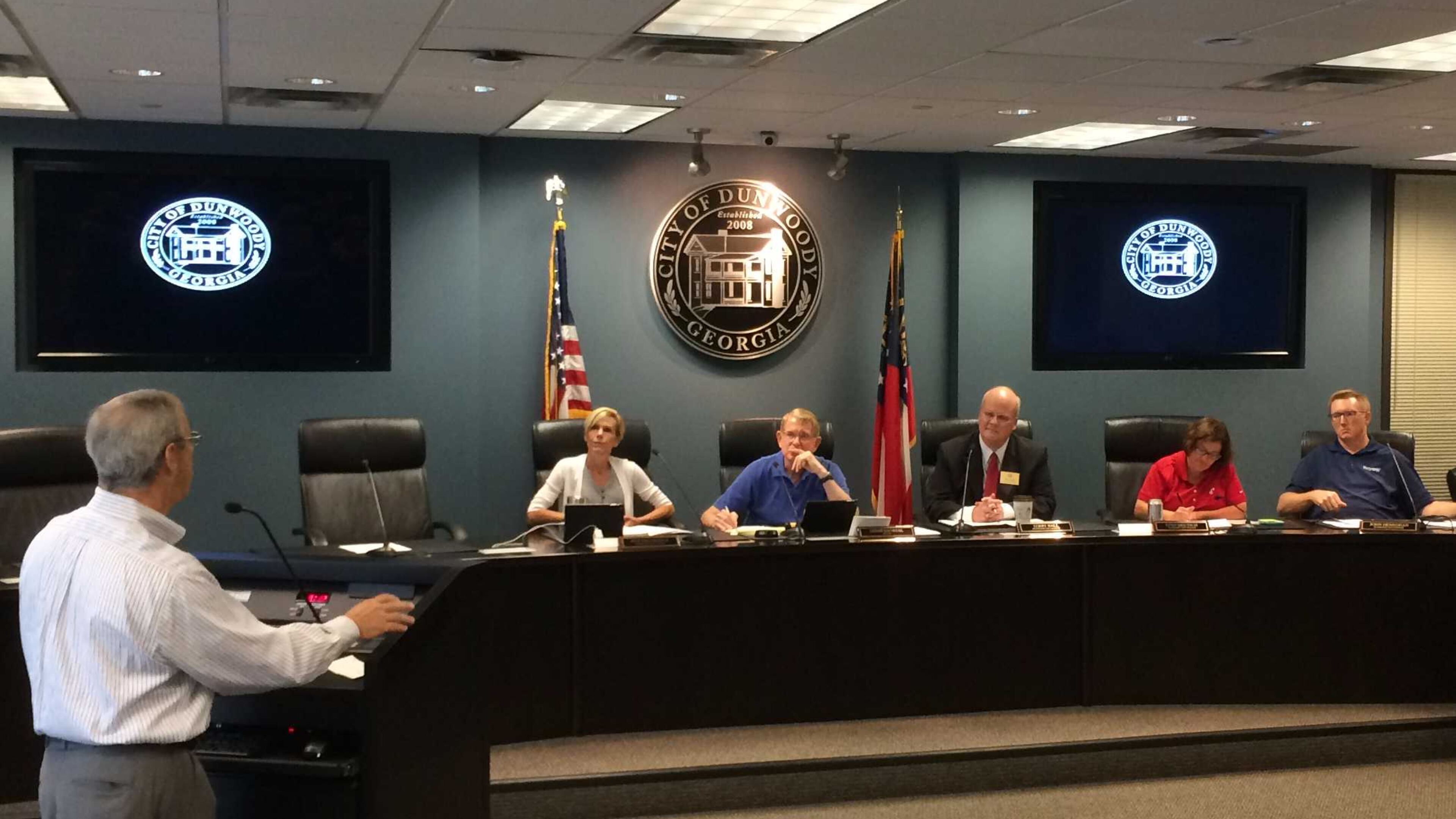 Dunwoody Homeowners Association President Robert Wittenstein speaks to the Dunwoody City Council on June 24 as it considers whether HOA members can also serve on city boards. Seated are Councilwoman Pam Tallmadge, Mayor Denis Shortal, Councilman Terry Nall, Councilwoman Lynn Deutsch and Councilman John Heneghan. MARK NIESSE / MARK.NIESSE@AJC.COM