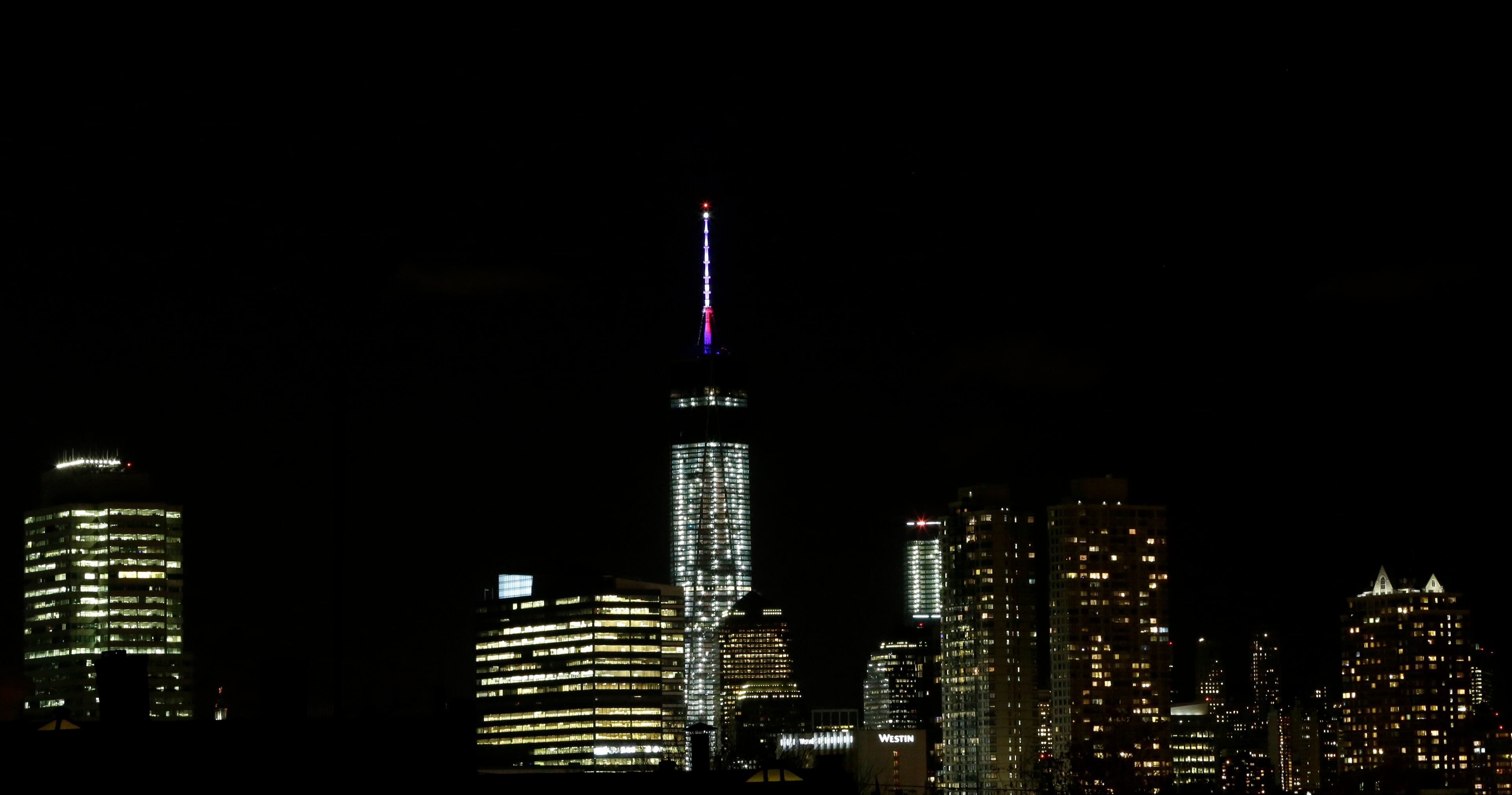 The beacon and spire of One World Trade Center are lit up, as seen from The Heights neighborhood of Jersey City, N.J., Friday, Nov. 8, 2013. The Port Authority of New York and New Jersey, who tested the lights on Friday, said the beacon is packed with nearly 300 modules and their glow can be seen for up to 50 miles. The beacon and spire together stand 408 feet tall and bring the building, formerly called the Freedom Tower, to its symbolic height of 1,776 feet. The Durst Organization operates the spire, which will serve broadcasters. (AP Photo/Julio Cortez)