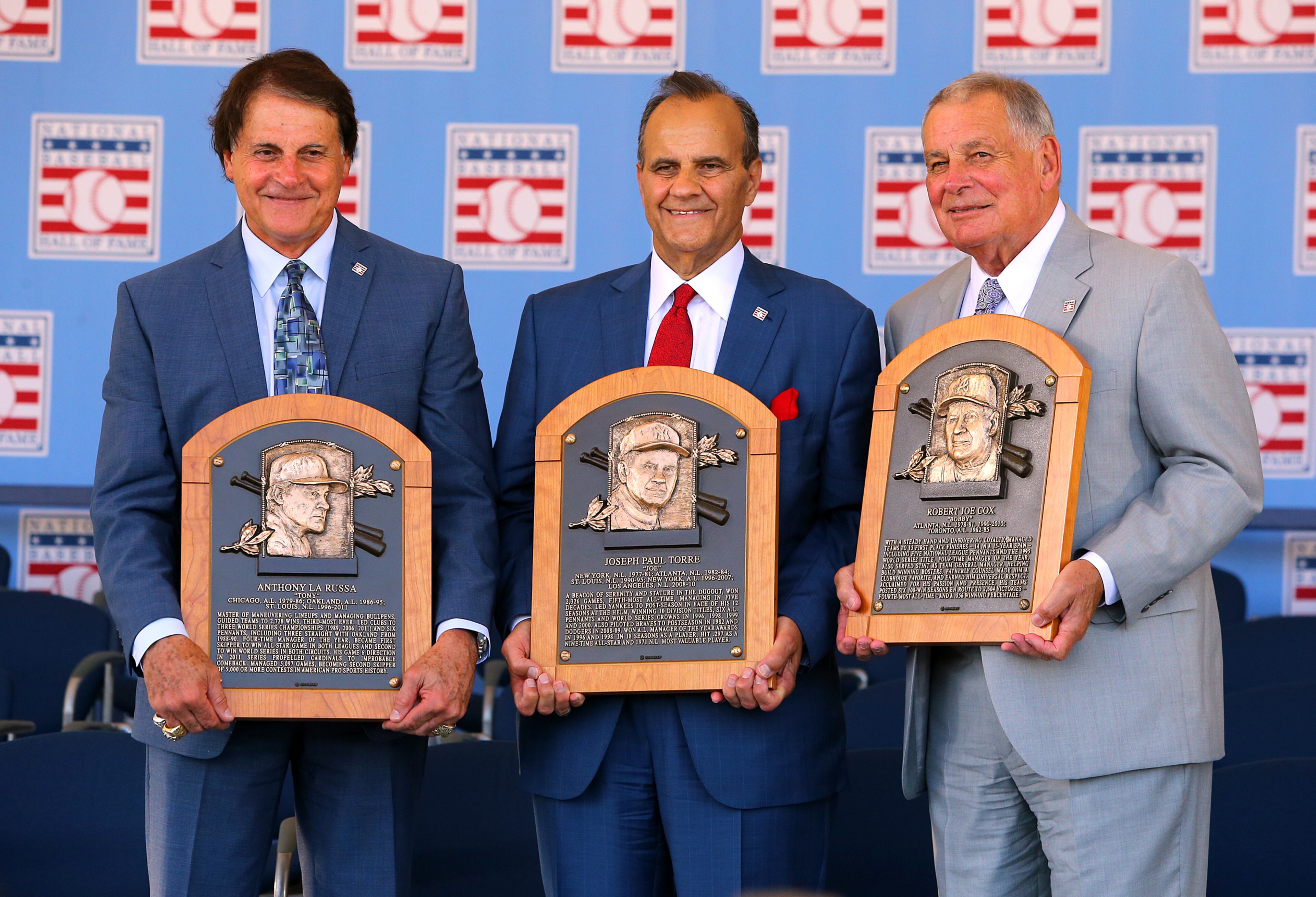 Managers Tony La Russa (from left), Joe Torre, and Bobby Cox hold their plaques. CURTIS COMPTON / CCOMPTON@AJC.COM
