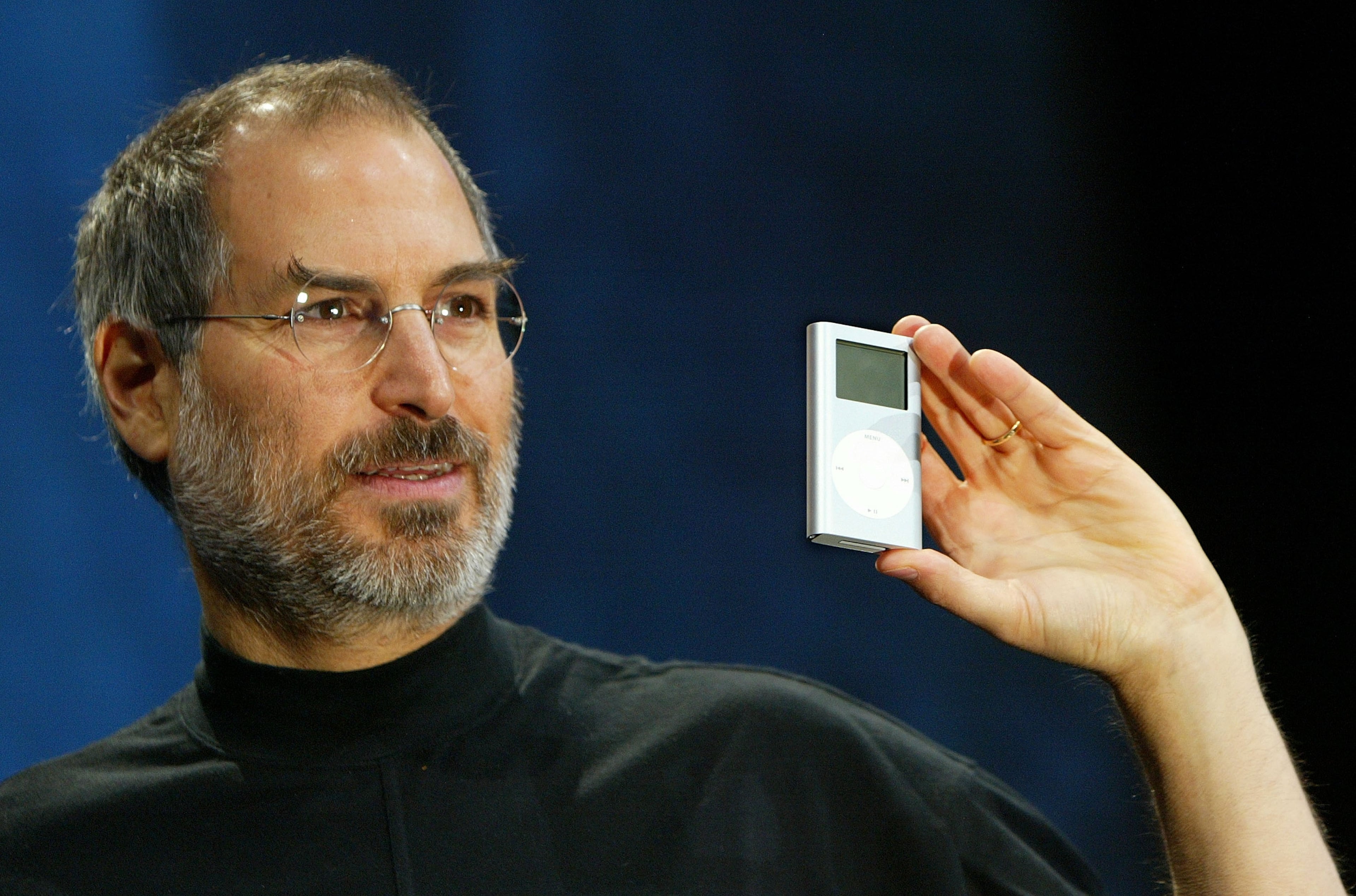 Apple CEO Steve Jobs holds a new mini iPod at Macworld January 6, 2004 in San Francisco. Jobs announced several new products including the new iLife 4 software and the Mini iPod. (Photo by Justin Sullivan/Getty Images)