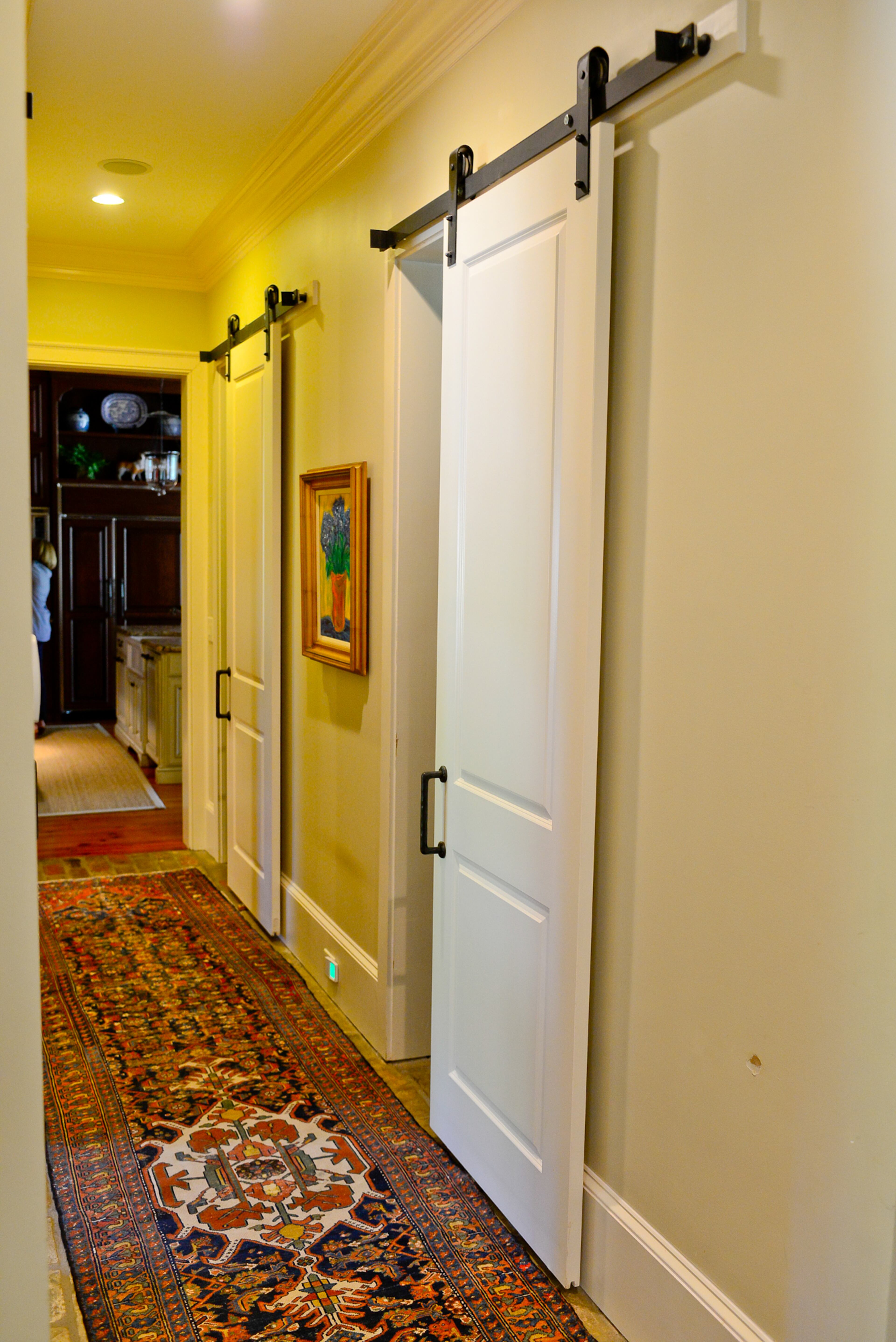 Sliding barn doors in an hallway are by Leigh Hattaway Interiors.