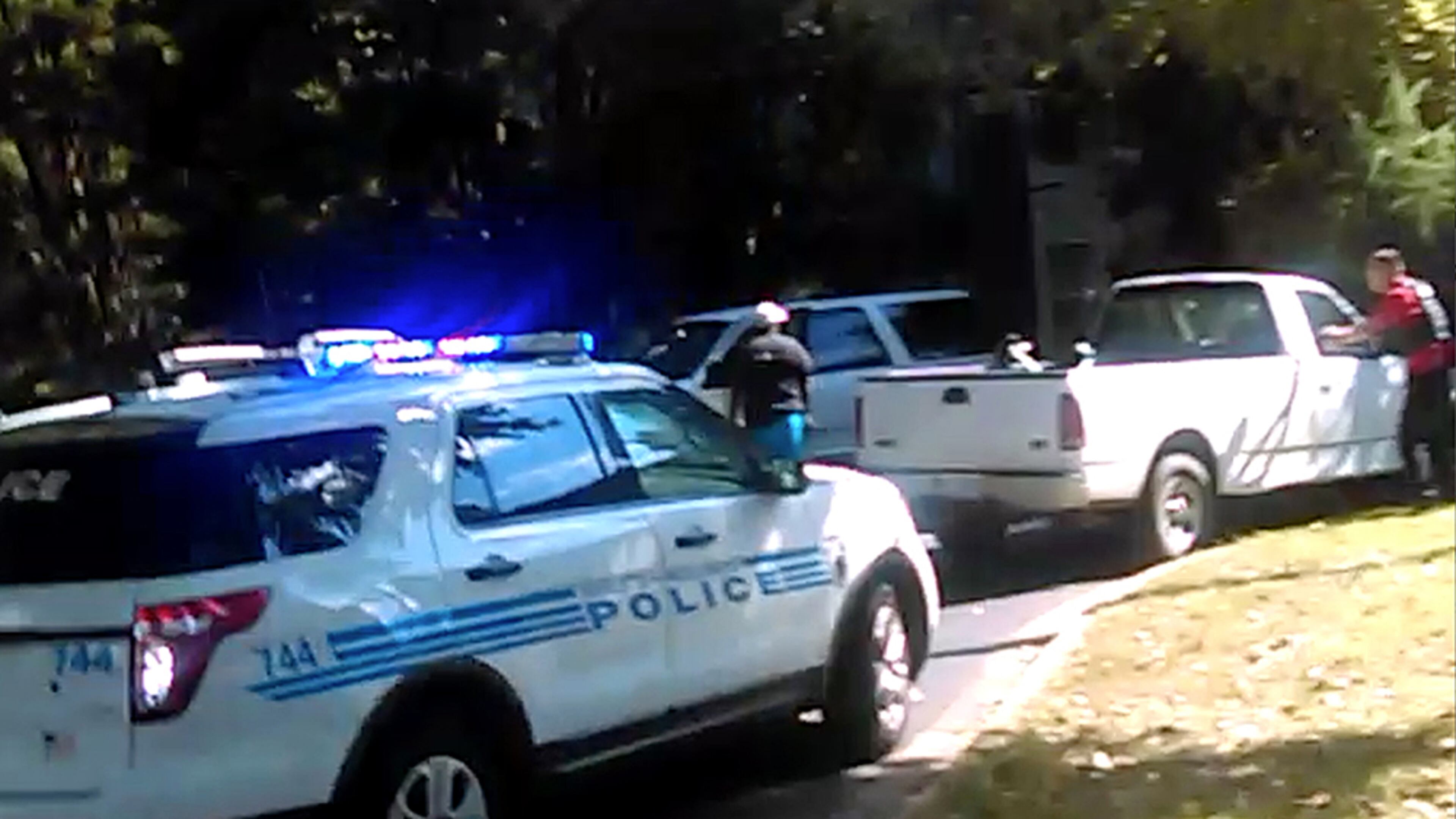 In this image taken from video recorded by Rakeyia Scott on Tuesday, Sept. 20, 2016, her husband, Keith Lamont Scott, center, stands amid Charlotte police cars and other vehicles moments before he is shot by a police officer in Charlotte, N.C. In the video of the deadly encounter, Rakeyia Scott repeatedly tells officers her husband, who is black, is not armed and pleads with them not to shoot him as they shout at him to drop a gun. The video does not show clearly whether Scott had a gun. (Rakeyia Scott/Curry Law Firm via AP)