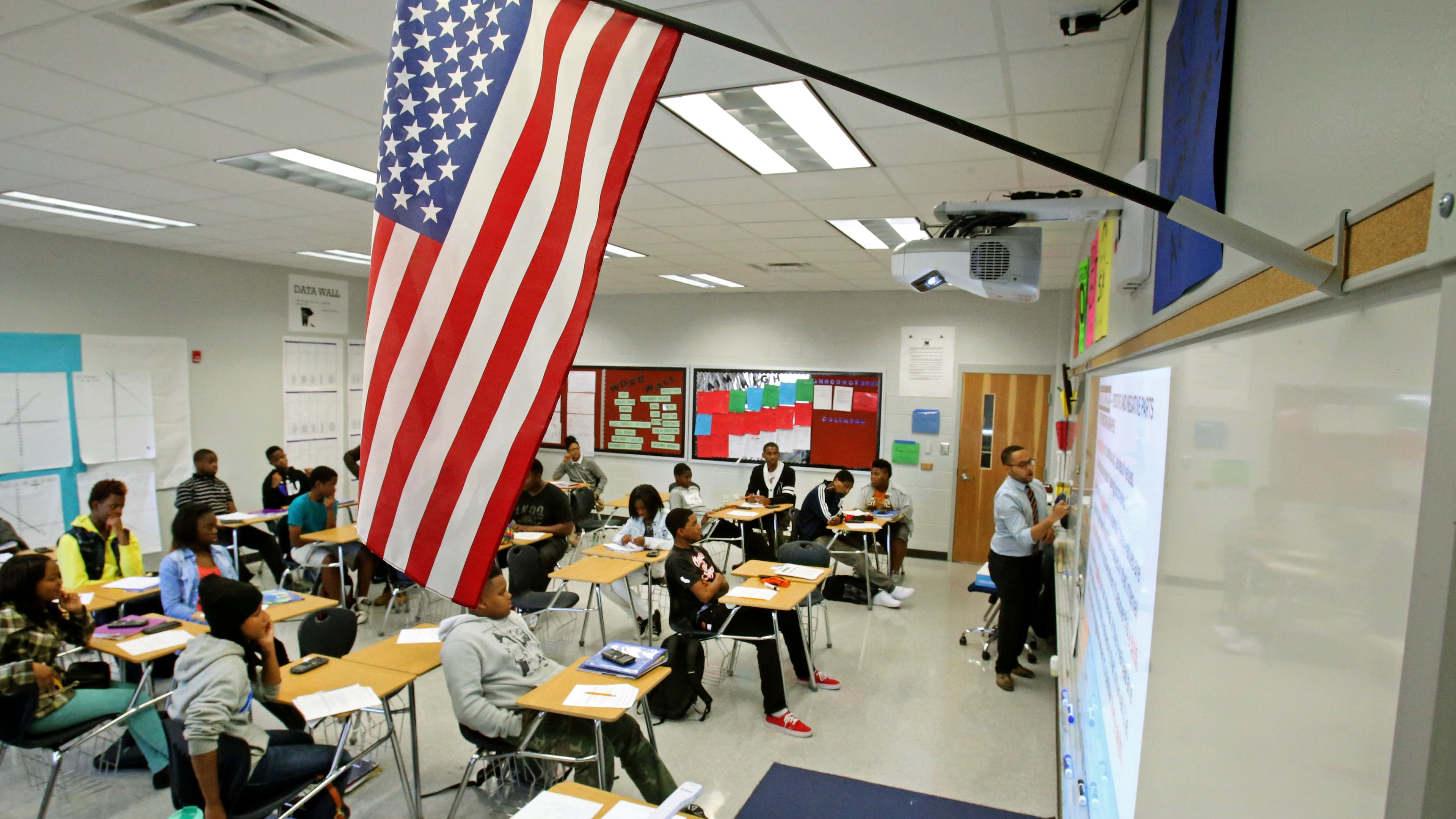 Below a U.S. flag, mathematics teacher Evan Shields teaches a ninth grade algebra class at Banneker High School in College Park. (Jason Getz/AJC 2013)