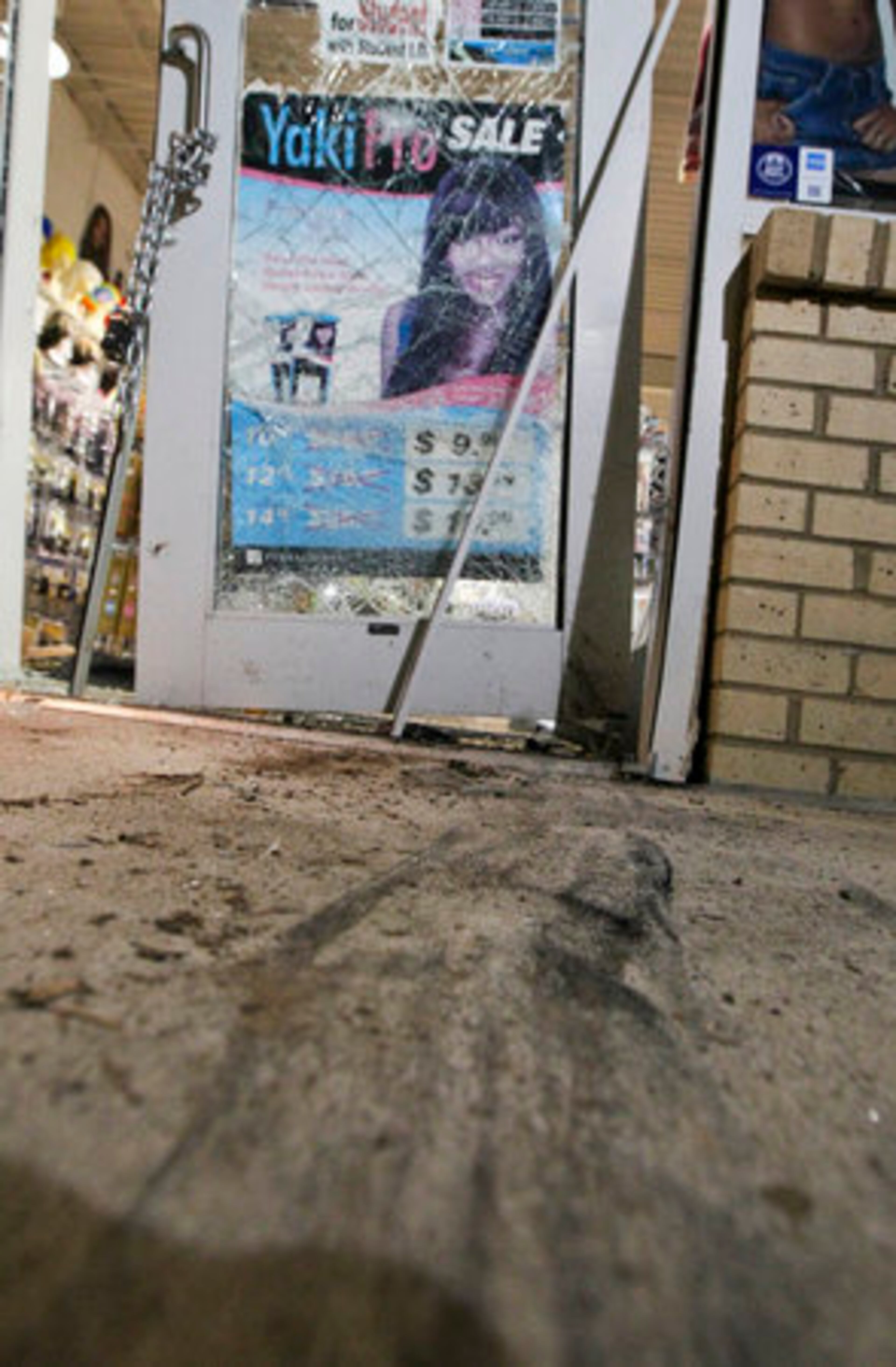 Tire tracks were visible where the car smashed through the doors. The burglars fled in another car. Police removed the stolen vehicle that crashed through the doors and was left partially inside.