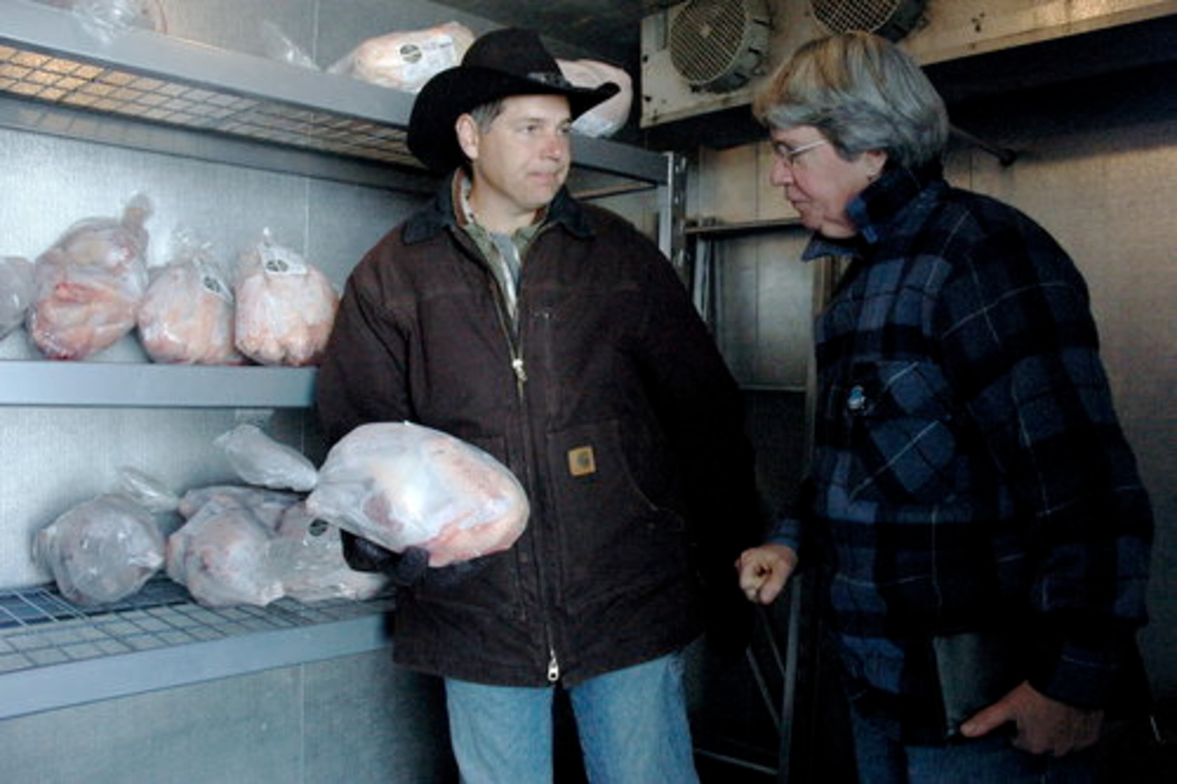 Some turkey buyers drove as long as three hours to visit the farm and pick up heritage breed turkeys on the Saturday before Thanksgiving. Tim Young helps Jane Russell, of Athens, pick a turkey from the walk-in freezer.