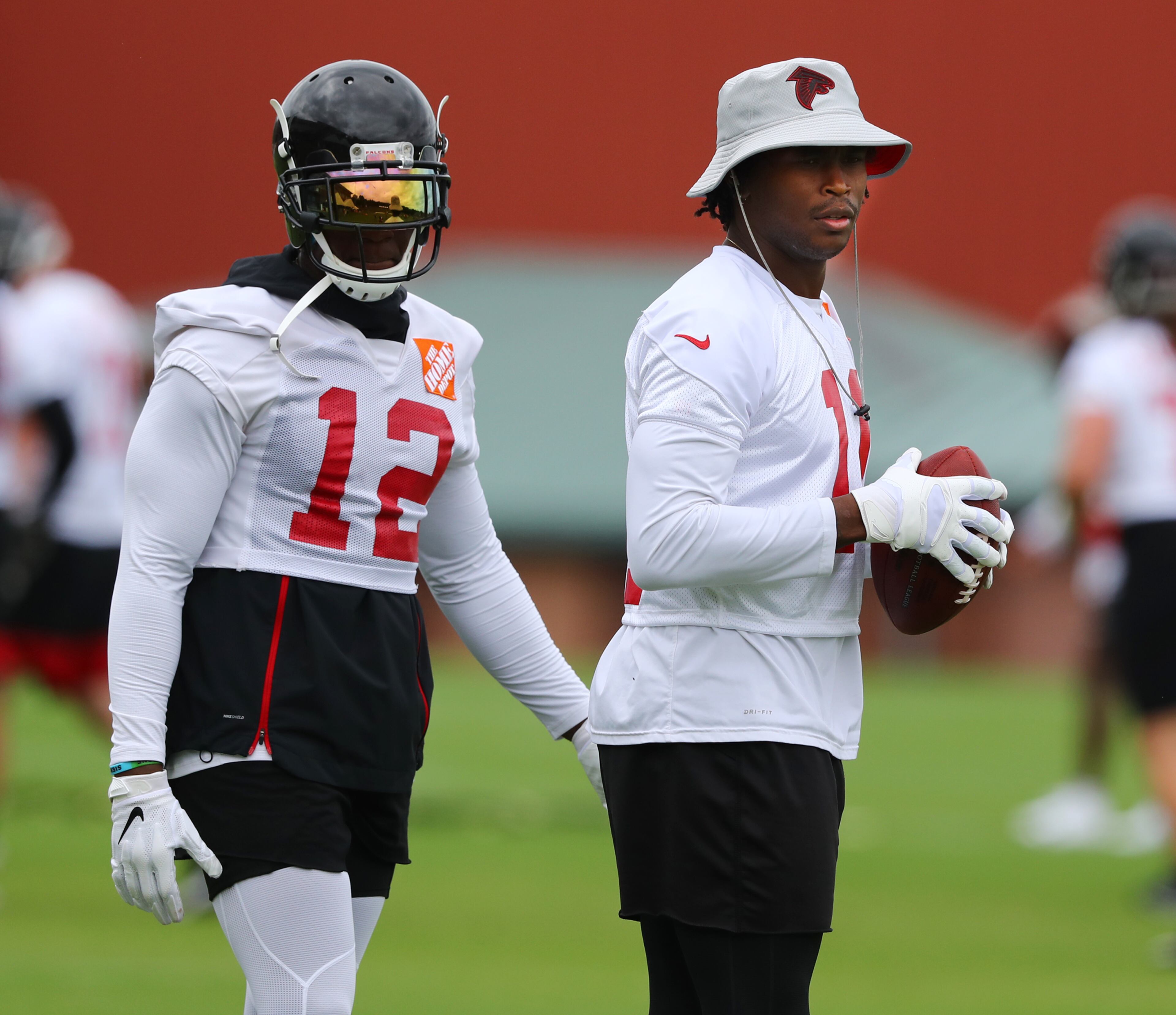 Receivers Mohamed Sanu and Julio Jones watch younger players run routes during Wednesday's action. (Curtis Compton/ccompton@ajc.com)