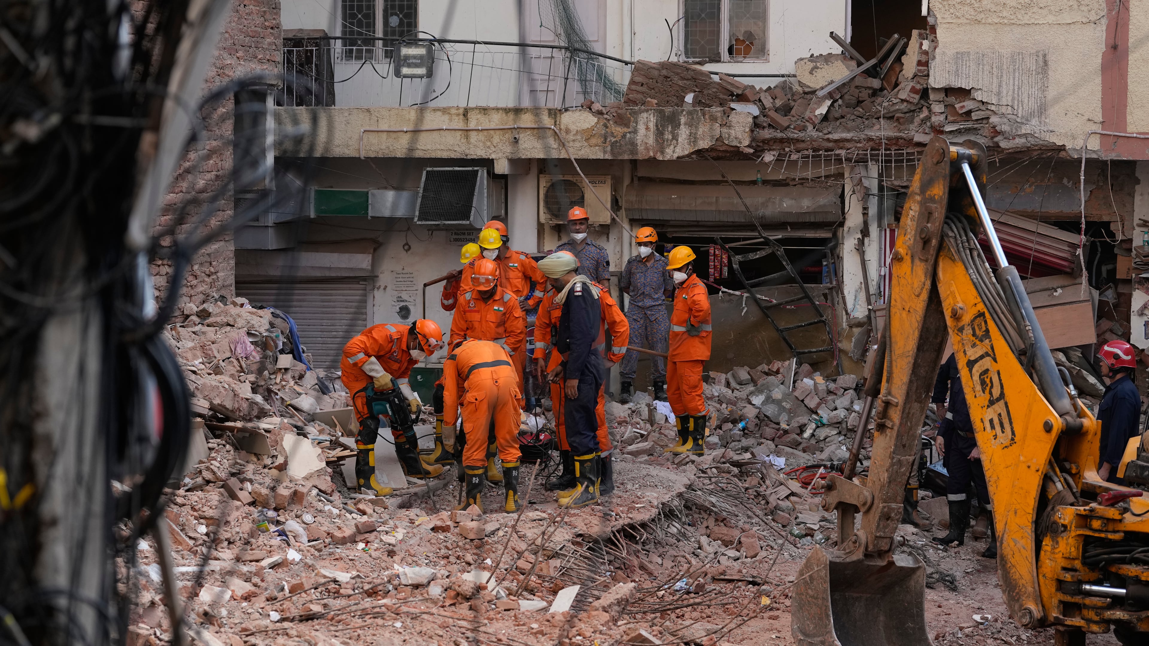 Rescue workers continue to search for people trapped under the debris of a collapsed building in New Delhi, India, Monday, Sept. 7, 2026. (AP Photo/Manish Swarup)