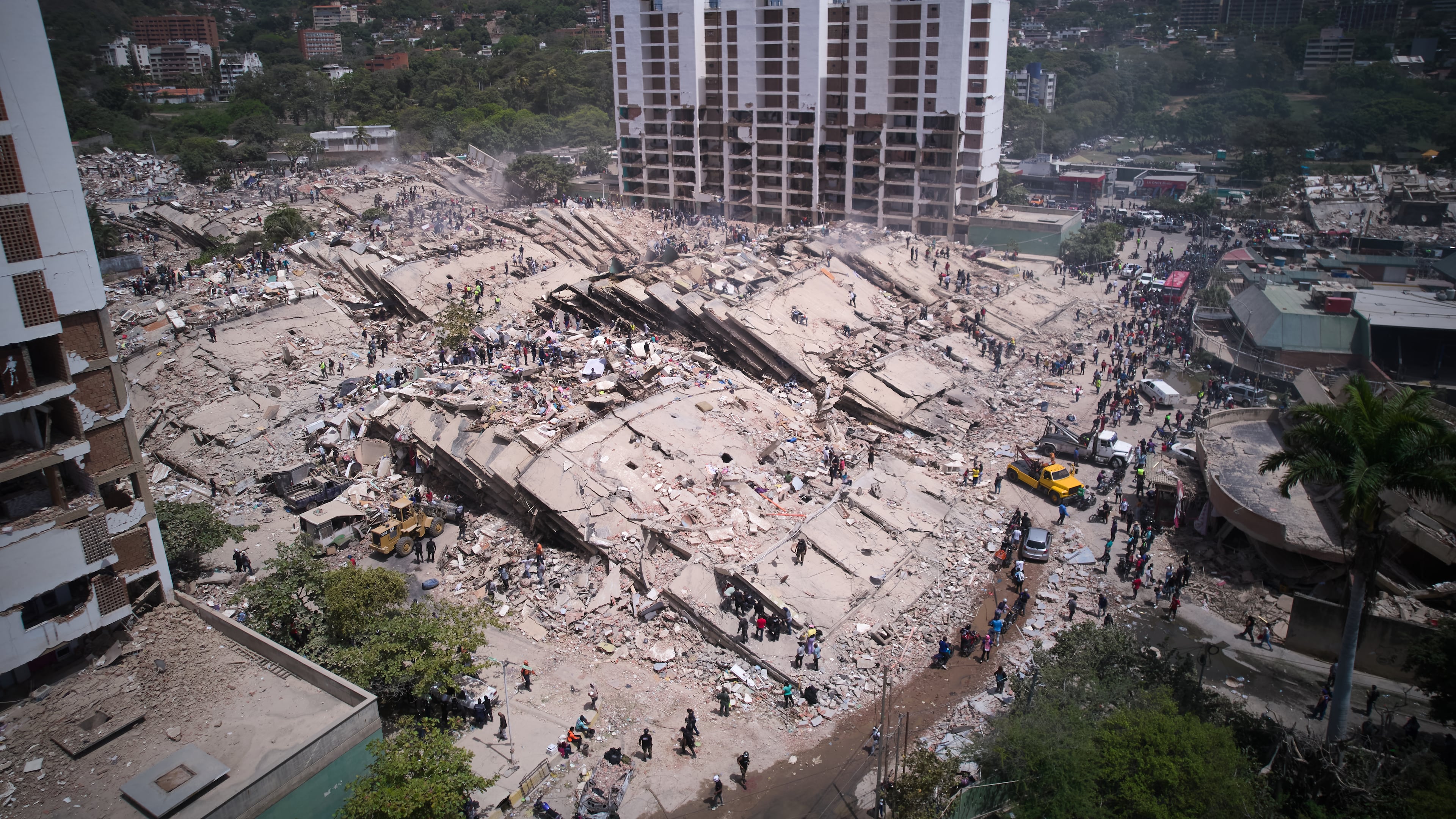 Residents and rescue workers search through the rubble two days after an earthquake struck La Guaira, Venezuela, Friday, June 26, 2026. (AP Photo/Juan Pablo Arraez)