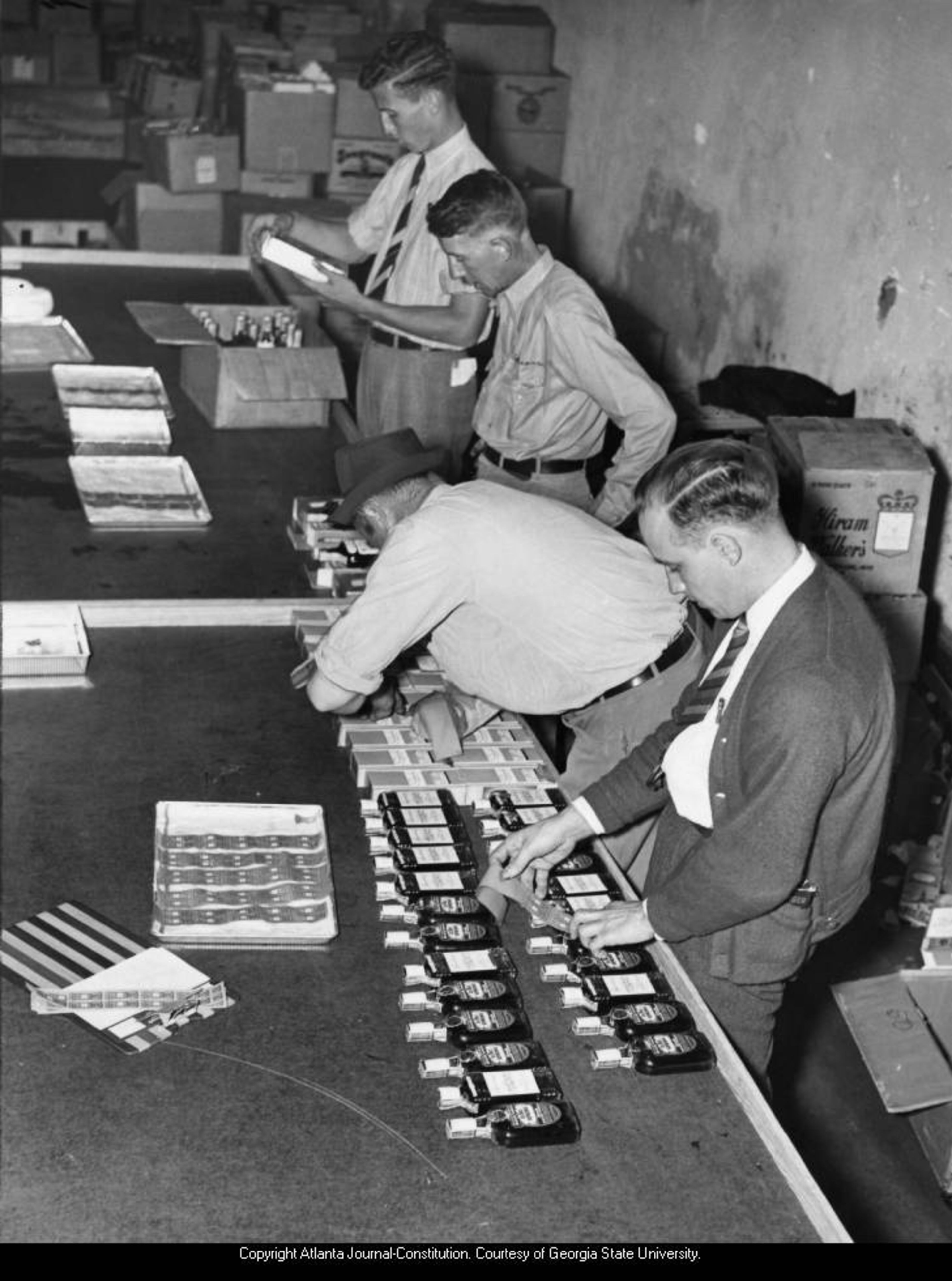 1938 -- B. R. Bowden and J. A. Hightower stamping some of the first liquor to be removed from the warehouse for the start of Albany's legalized sale. AJC PHOTO ARCHIVES