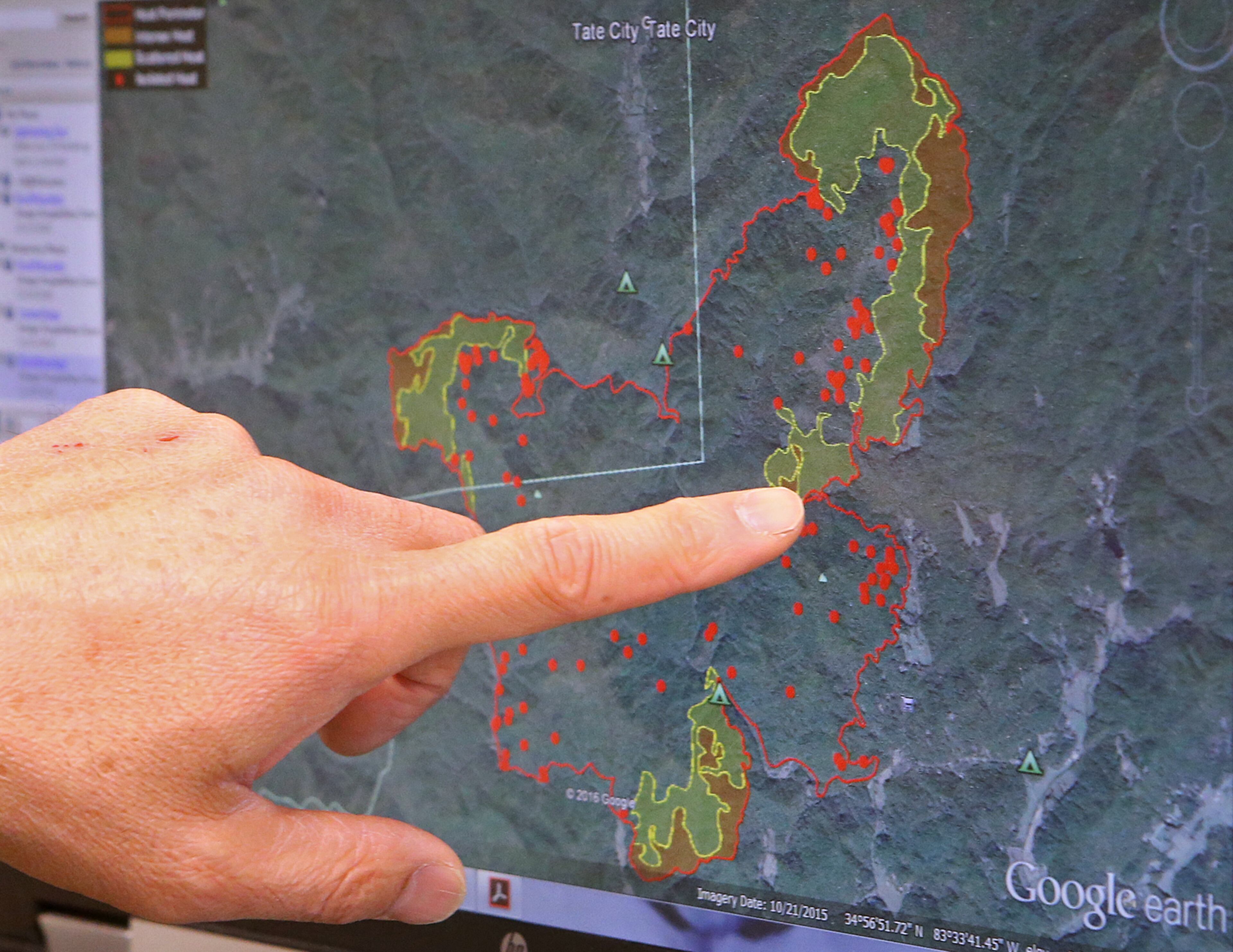Stan Hinatsu, United States Department of Agriculture Forest Services, points out Rock Mountain fire hot spots on a map on his computer in the command post on Tuesday, Nov. 15, 2016, in Clayton. Curtis Compton/ccompton@ajc.com
