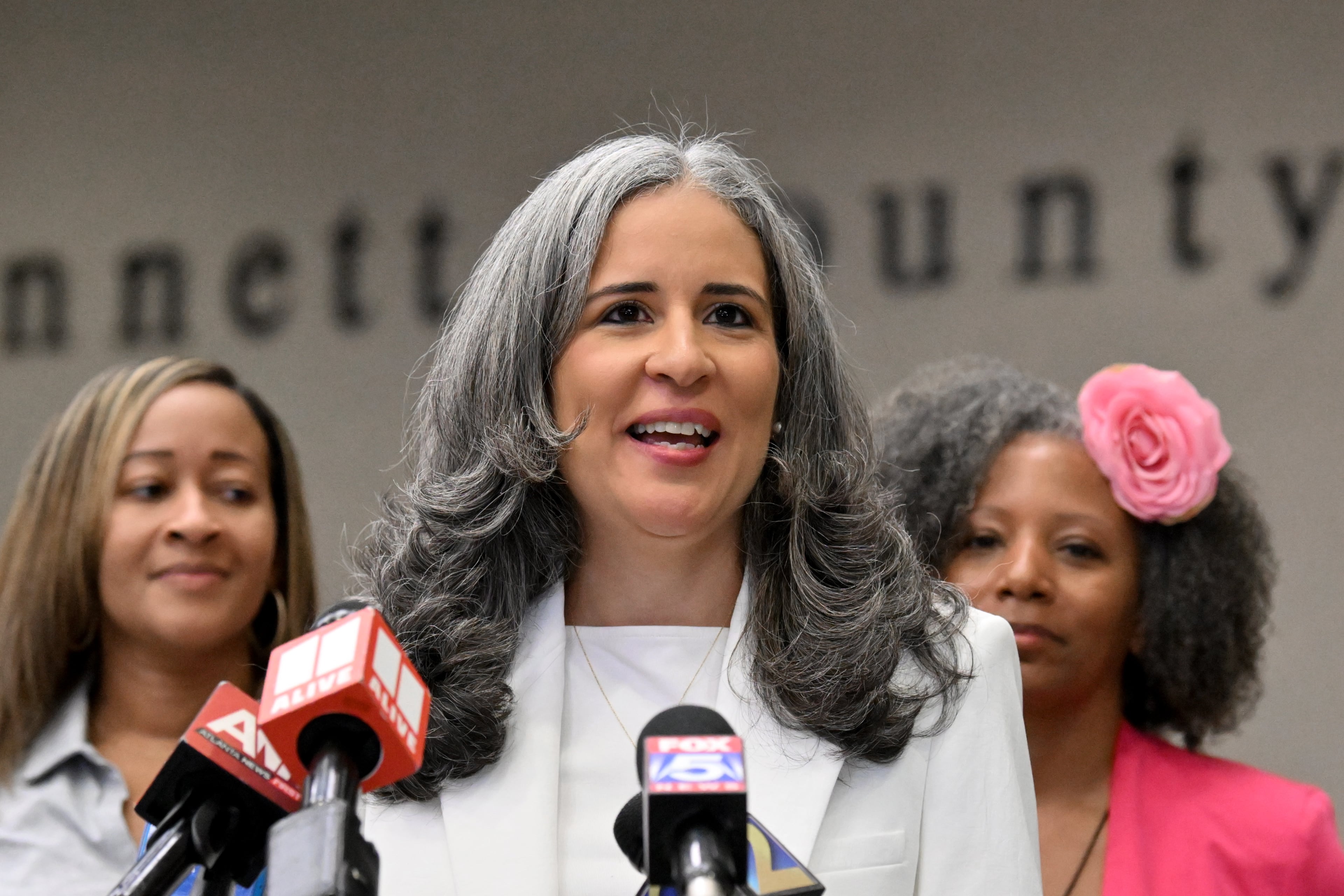 Alexandra Estrella, recently hired to be the next Gwinnett County Public Schools superintendent, speaks to reporters as school board members stand behind her during a news conference at the district's headquarters in Suwanee on Saturday, April 4, 2026. (Hyosub Shin/AJC)