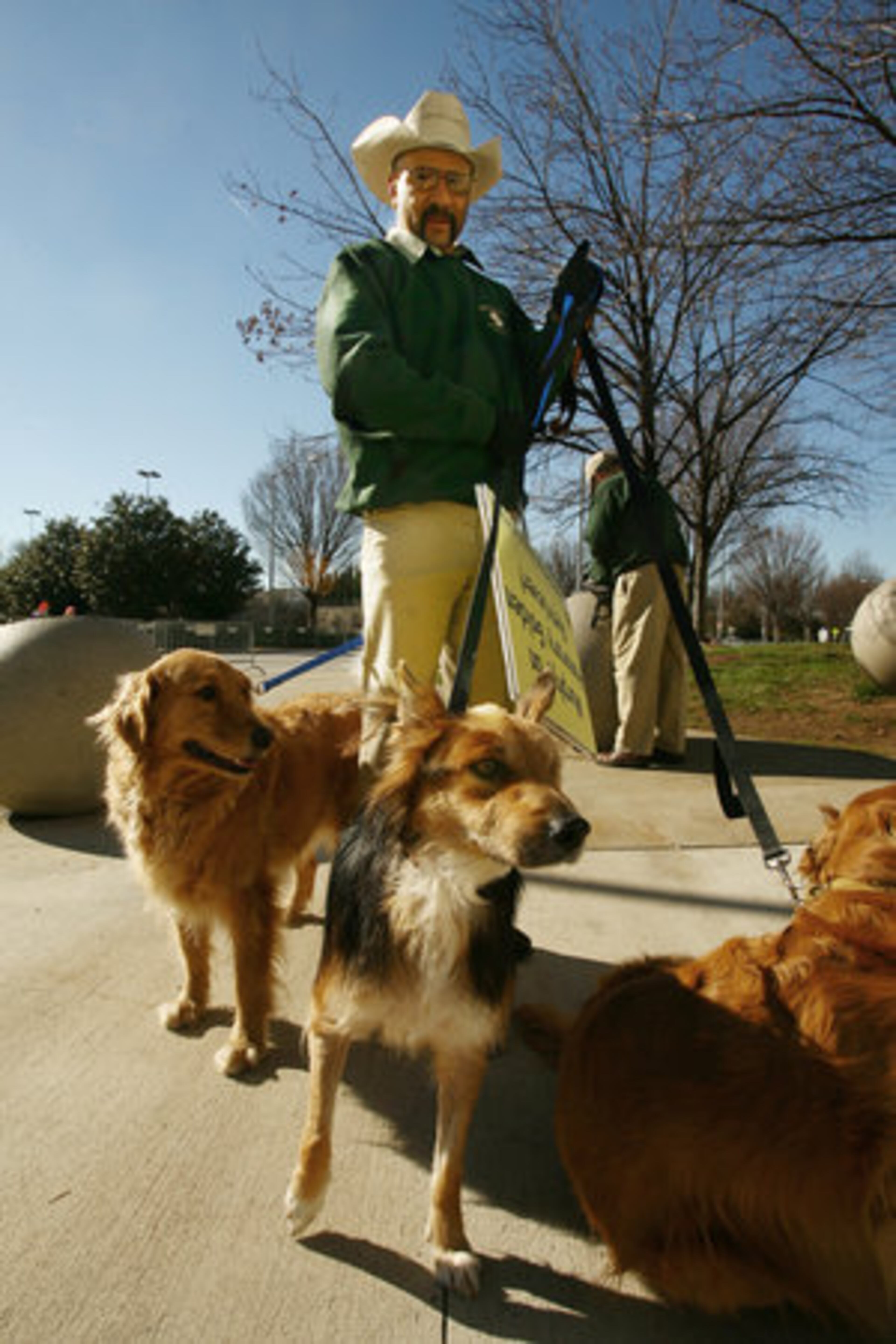 Carter Robinson of Magdelena, N.M., takes care of handling Murphy (center) along with Stella, (at left, background). Murphy was found badly beaten, allegedly by his previous owner, in Murphy Candler Park and rescued by Robert Kennedy of Atlanta, who currently owns the dog.