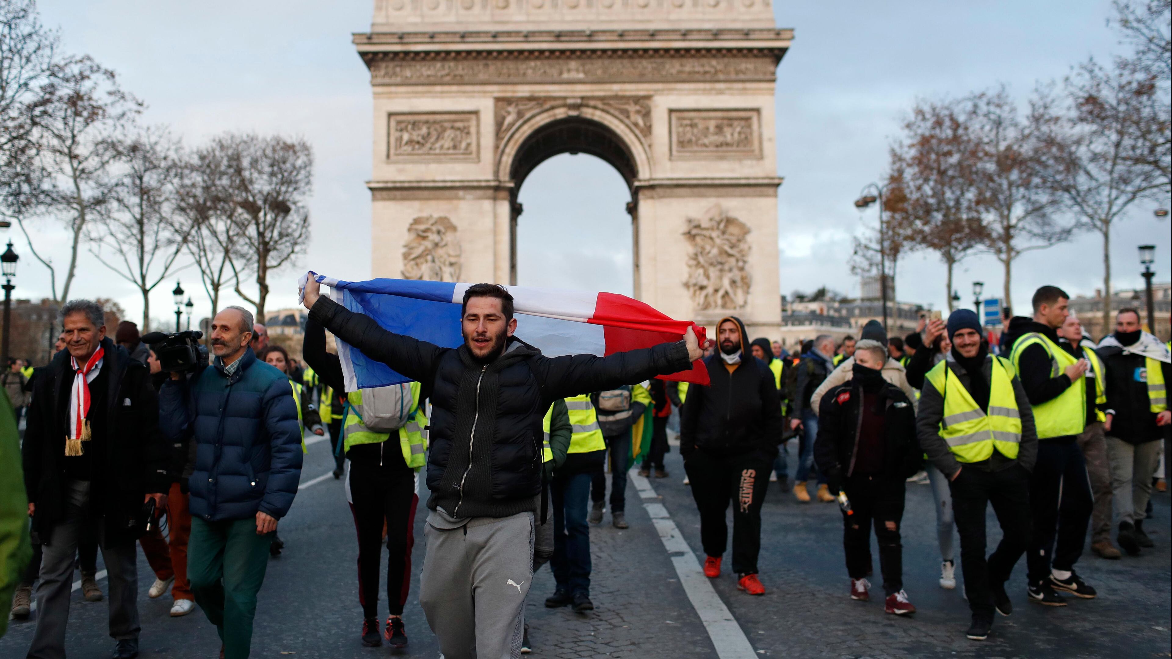 Demonstrators wearing yellow vests march down the Champs Elysees in Paris on Saturday.