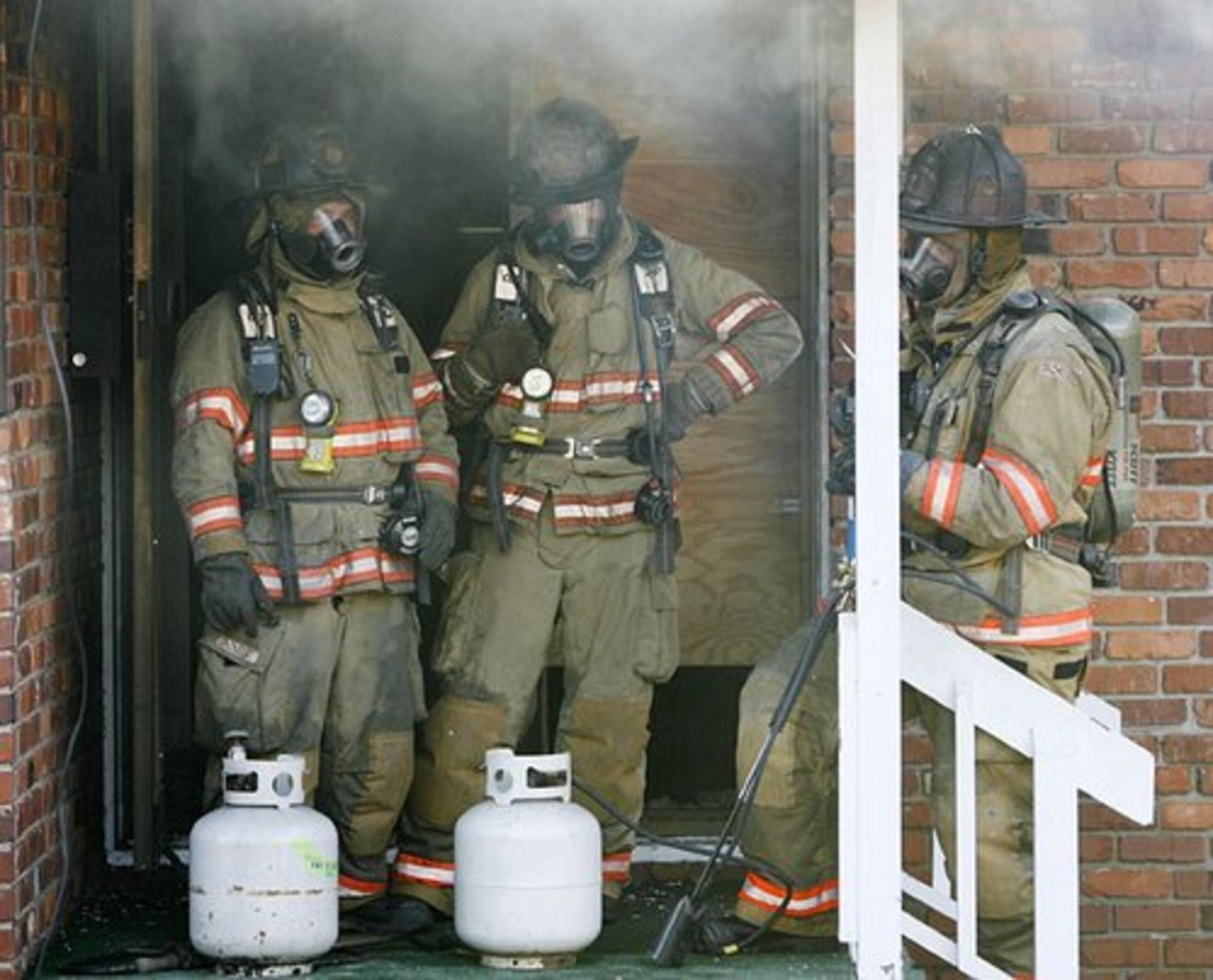 The ignition team prepares to burn the house using old shipping pallets as fuel and lighting them with propane torches.