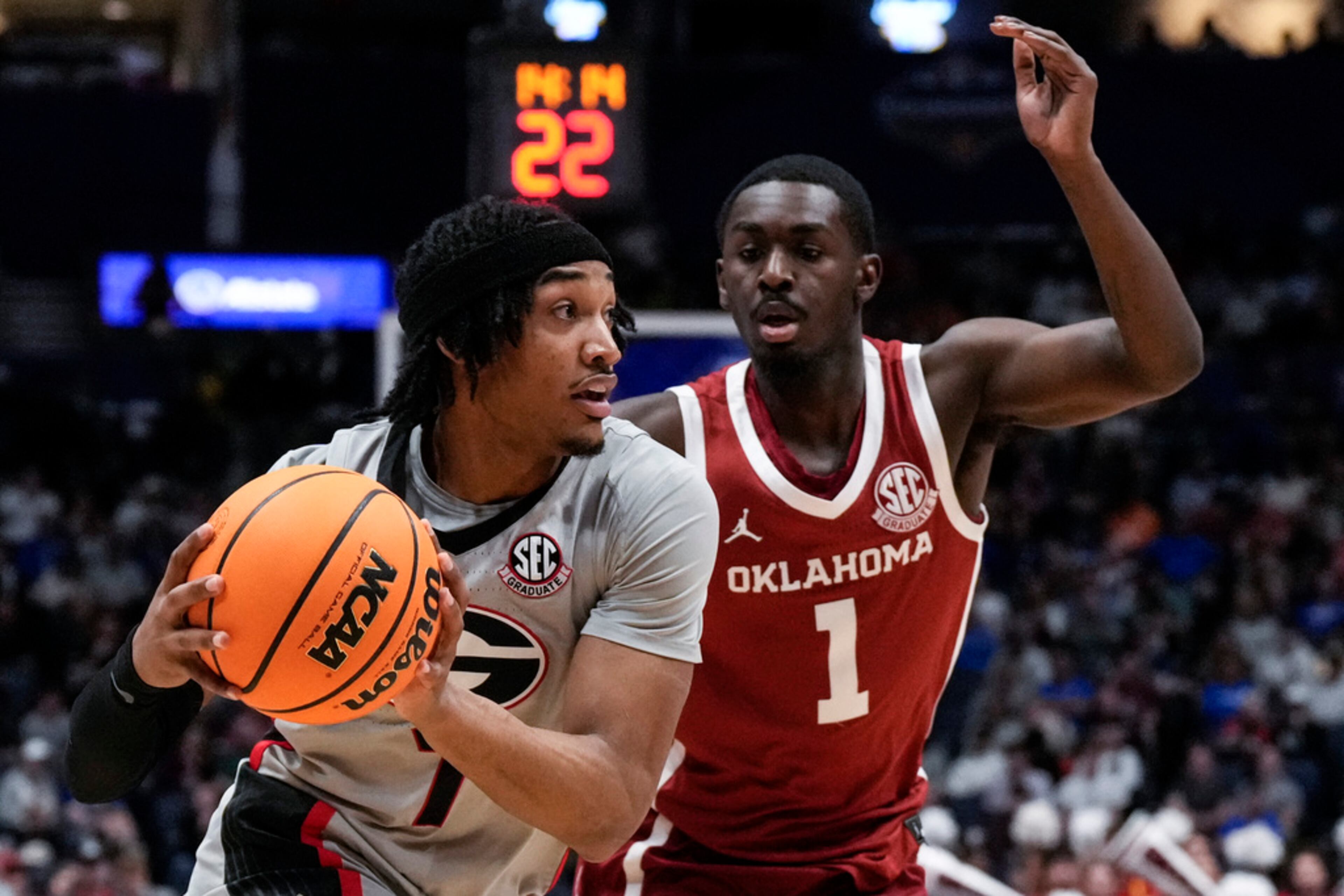 Georgia guard Tyrin Lawrence (7) looks for a teammate against Oklahoma guard Kobe Elvis (1) during the first half of an NCAA college basketball game at the Southeastern Conference tournament, Wednesday, March 12, 2025, in Nashville, Tenn. (AP Photo/George Walker IV)