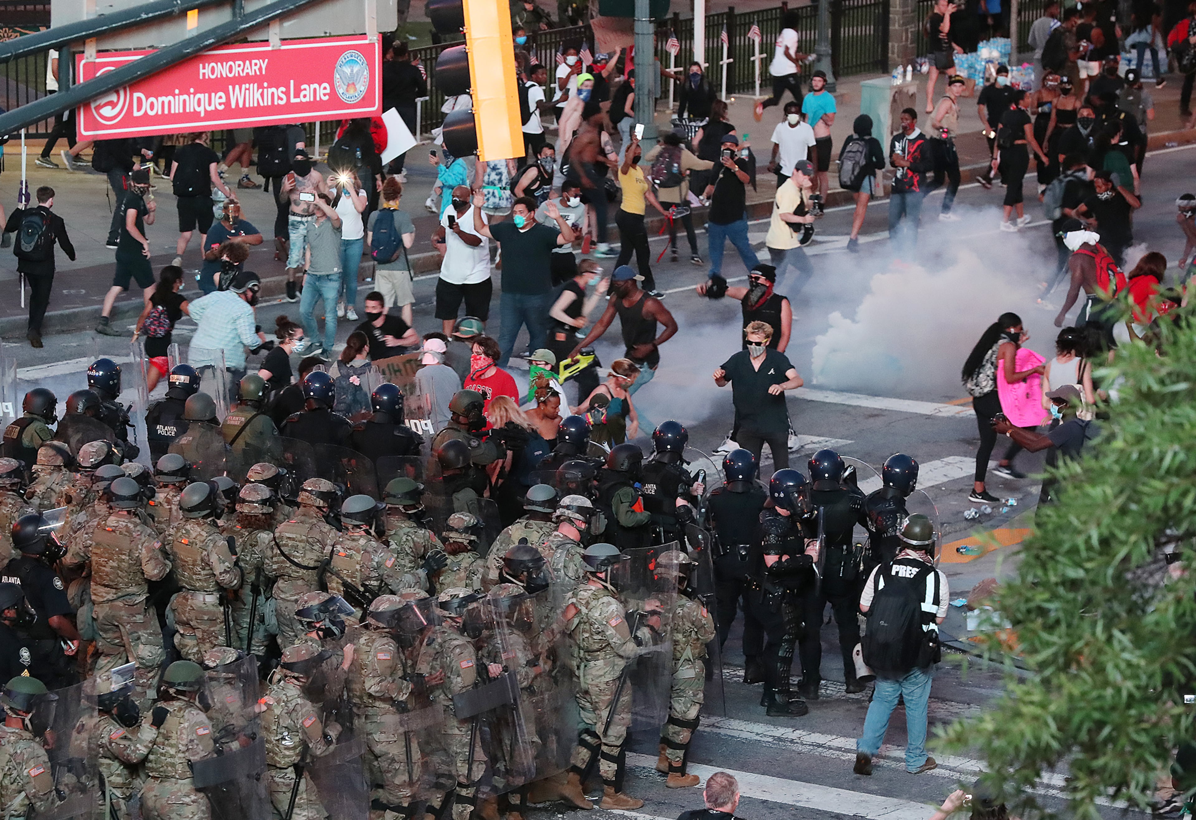 060220 Atlanta: Law enforcement officials and Georgia Army National Guard soldiers fire tear gas and advance on protesters on Centennial Olympic Park Drive outside the CNN Center at Olympic Park after curfew during a fifth day of protests over the death of George Floyd on Tuesday, June 2, 2020, in Atlanta. Curtis Compton ccompton@ajc.com