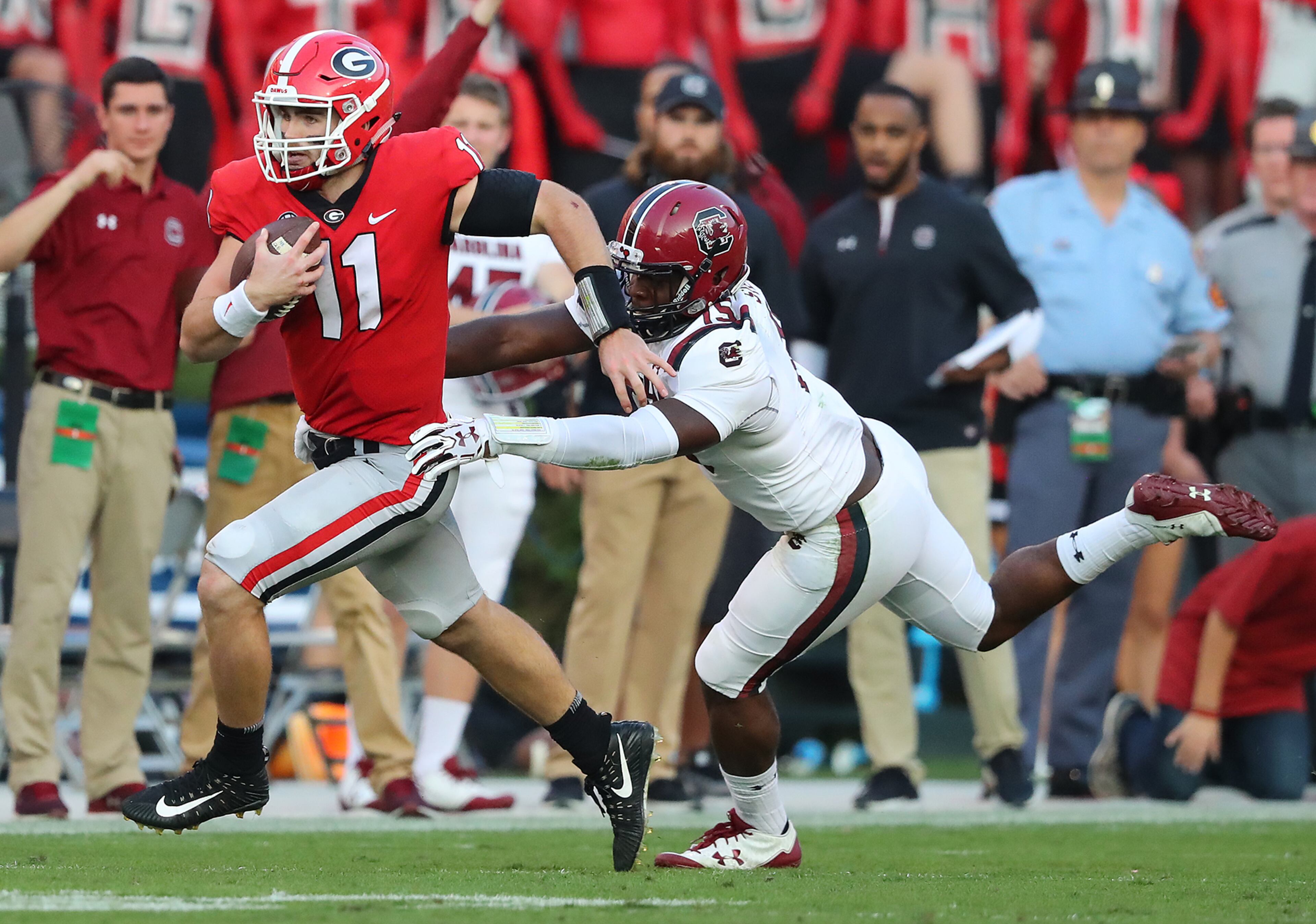 November 4, 2017 Athens: Georgia quarterback Jake Fromm picks up yardage against South Carolina defender Aaron Sterling during the second half in a NCAA college football game on Saturday, November 4, 2017, in Athens. Curtis Compton/ccompton@ajc.com