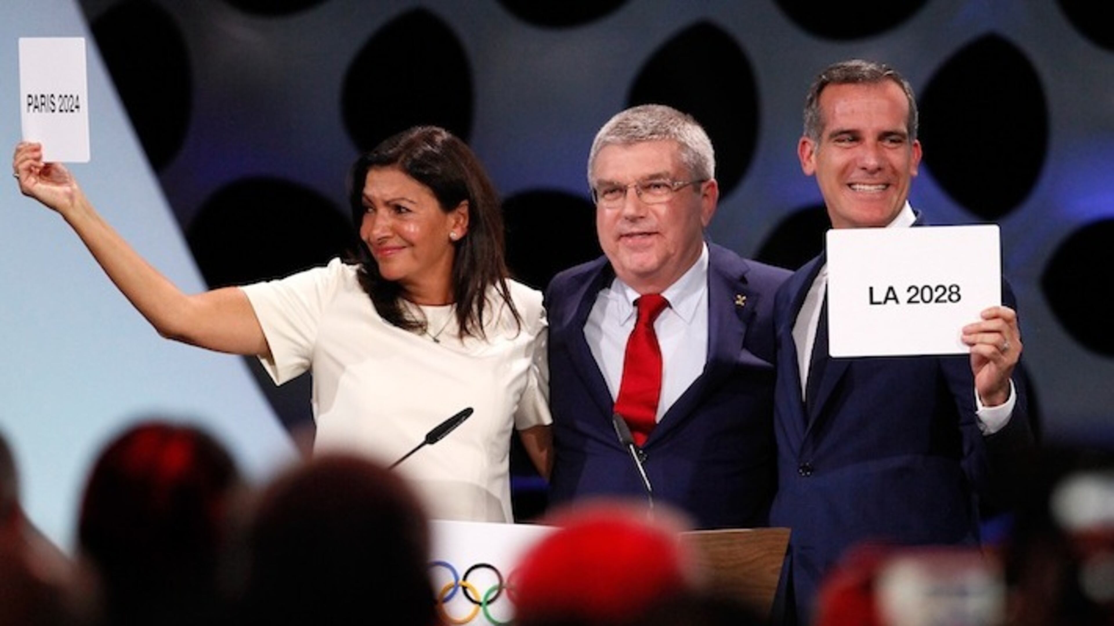 International Olympic Committee President Thomas Bach, middle, passes two cards to Anne Hidalgo, mayor of Paris, and Eric Garcetti, mayor of Los Angeles, during the presentation and announcement ceremony of the 2024 and 2028 Summer Olympic Games at the 131st IOC session in Lima, Peru, on September 13, 2017. (Luis Camacho/Xinhua/Sipa USA/TNS)