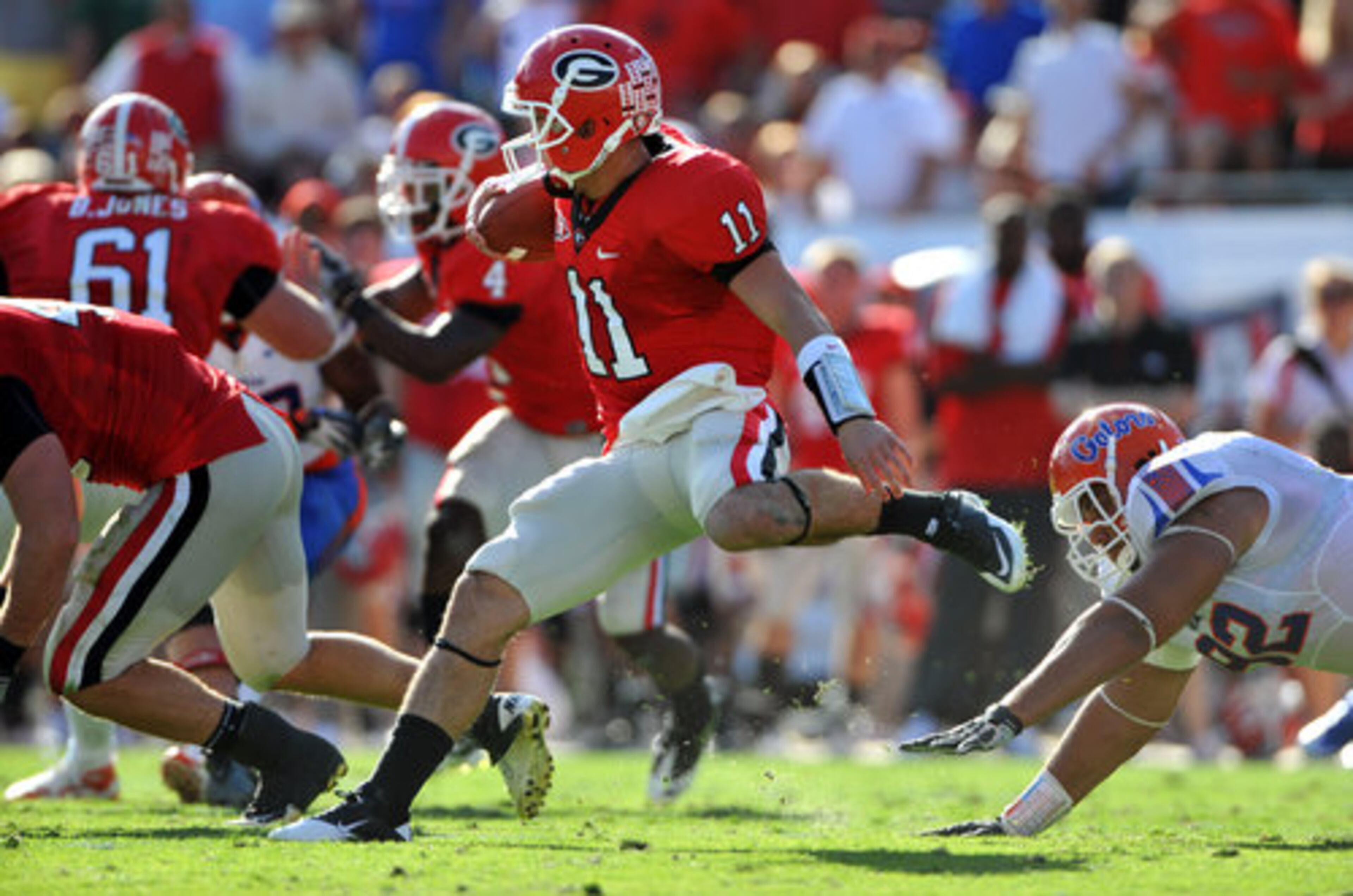 Georgia Bulldogs quarterback Aaron Murray eludes the tackle of Florida Gators defensive tackle Terron Sanders for a first down in the second quarter at EverBank Field in Jacksonville, FL Saturday October 30, 2010.