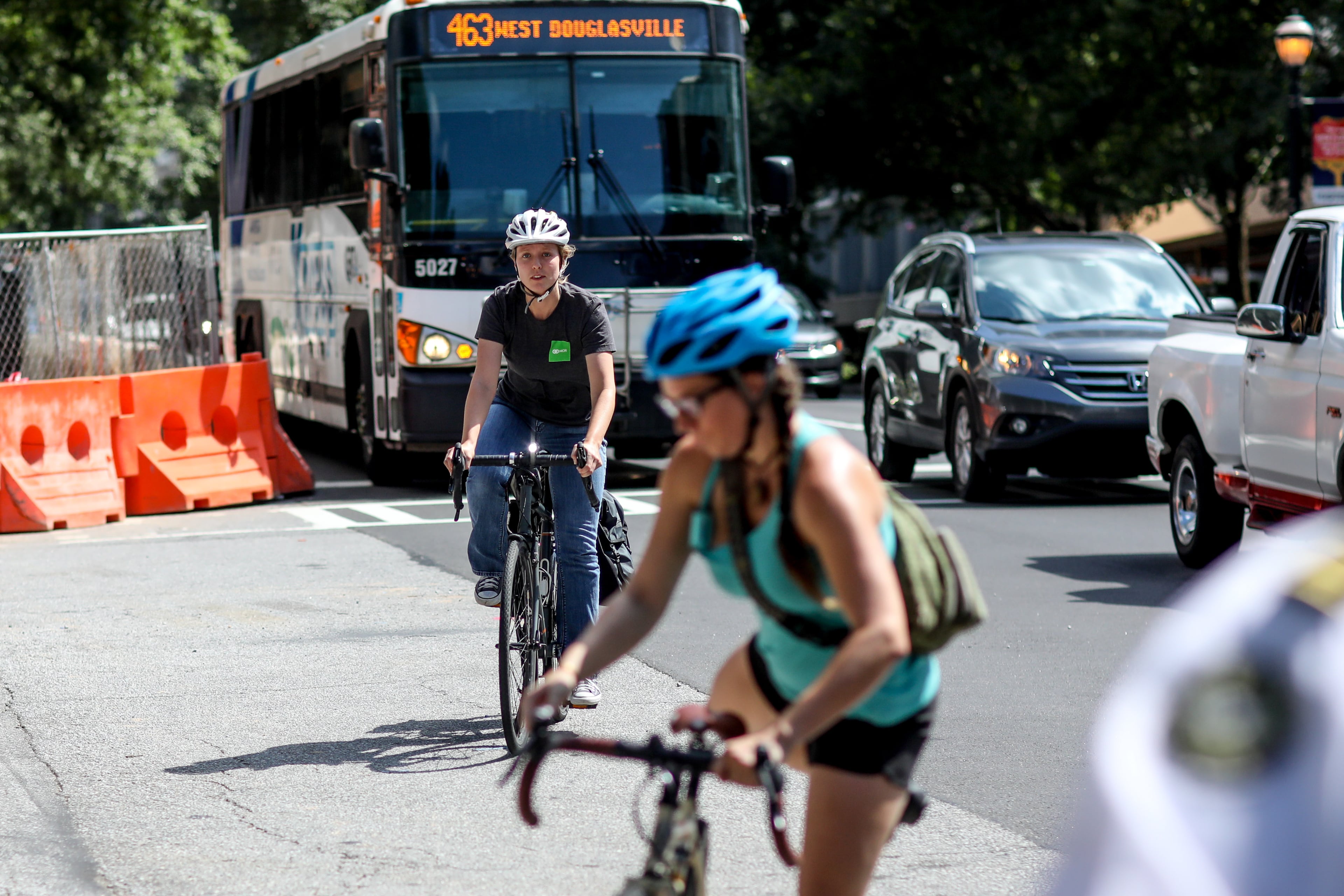 Two cyclist arrive for a rally on West Peachtree Street near where William Alexander was hit and killed by a bus while riding on a scooter, Wednesday, July 24, 2019, in Atlanta. Organizers joined together as a "human protected sidewalk, bike and scooter lane" demanding the city prioritize protected bike and scooter lanes. BRANDEN CAMP/SPECIAL