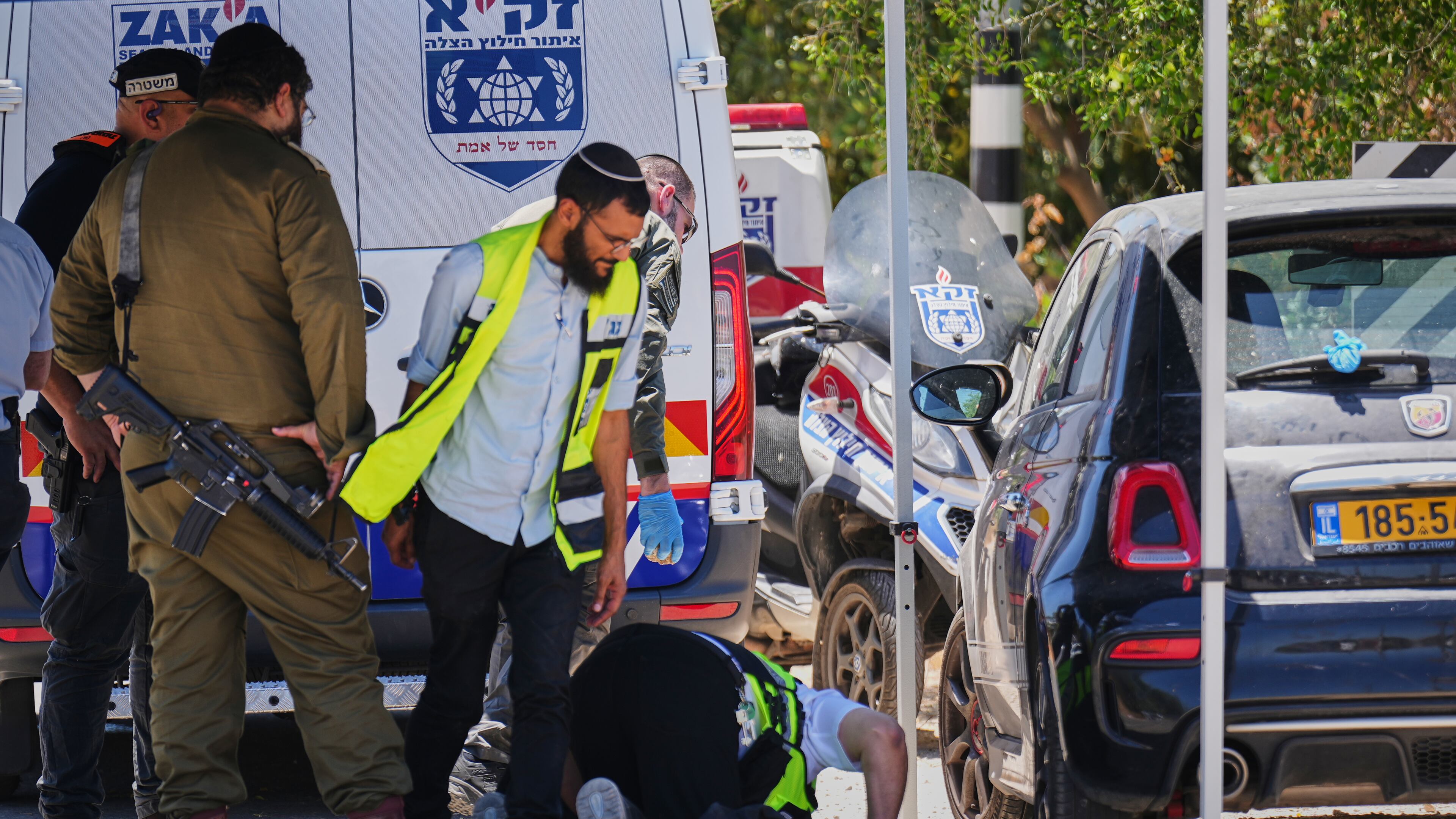 Israeli security forces and ZAKA rescue service volunteers respond at the scene of a shooting attack carried out by a Palestinian citizen of Israel near Tzur Yitzhak in central Israel, Sunday, June 7, 2026. (AP Photo/Ariel Schalit)