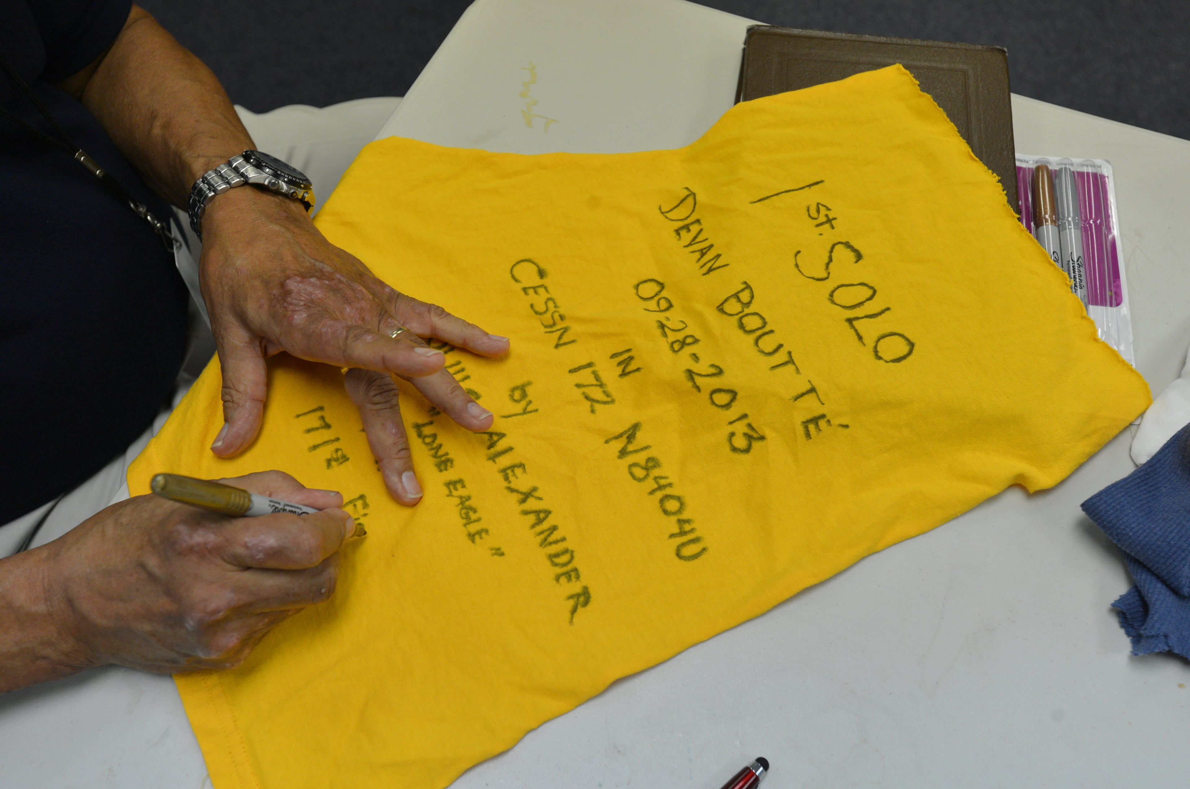 October 3, 2013 Atlanta: Julius Alexander, founder of Aviation Career Enrichment (ACE) records the solo flight information of his latest student on the back of a t-shirt Thursday October 3, 2013. The milestone of the student's first flight will take its place among the 170 others at the ACE headquarters. ACE begin in 1980 as a way to introduce disadvantaged, at-risk and minority youth to aviation opportunities. To date Alexander has instructed 171 students to their first solo flight. BRANT SANDERLIN /BSANDERLIN@AJC.COM