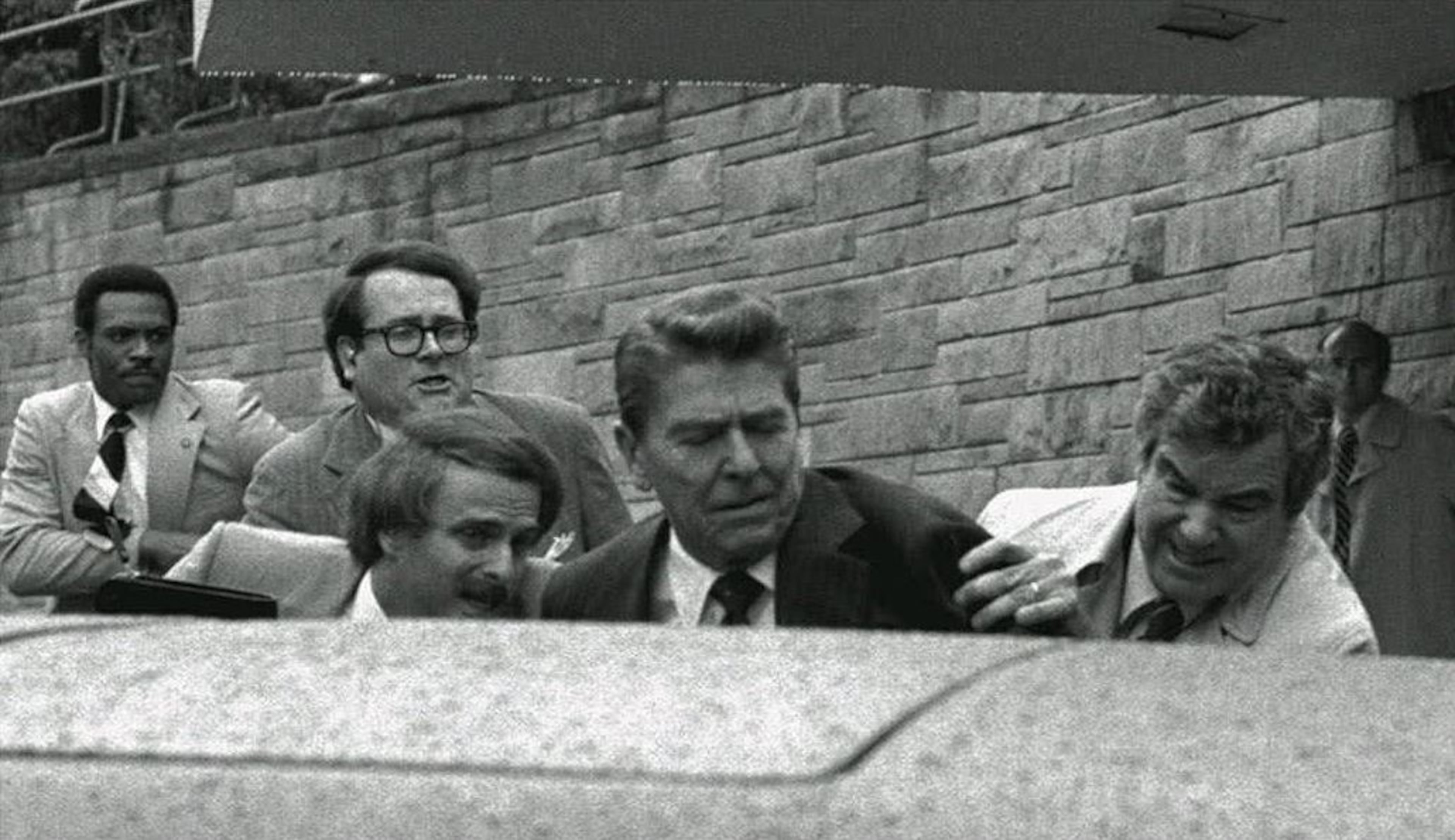 FILE - In this March 30, 1981 file photo, U.S. President Ronald Reagan winces and raises his left arm as he was shot by an assailant as he left a Washington hotel after making a speech to a labor group. After he was seriously wounded in a 1981 assassination attempt, Reagan described the experience simply in one of his presidential diaries: "Getting shot hurts." That excerpt and many others form a portrait of an uncomplicated and amiable man who, despite occasional periods of worry and bursts of temper, took his eight years in the White House pretty much in stride. (AP Photo/Ron Edmonds, File)