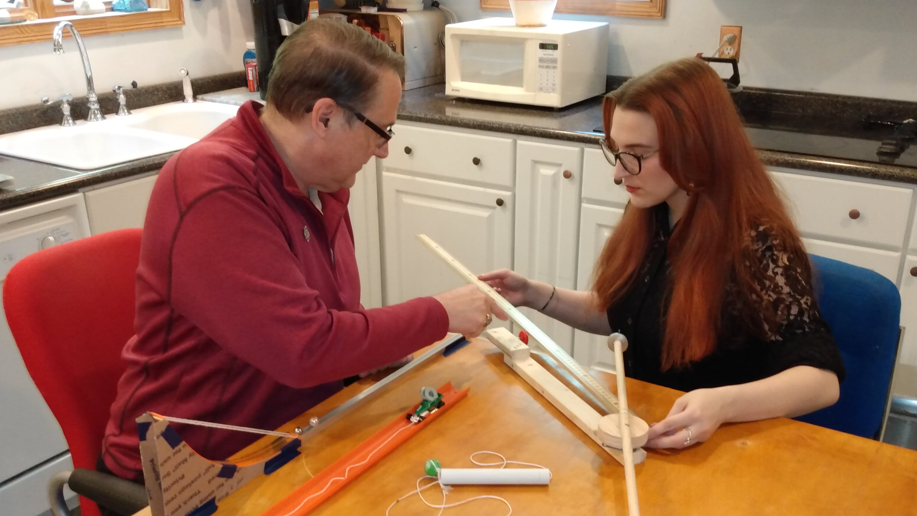 Oglethorpe University instructor Daniel Howard and his daughter, Jacqueline, try out his physics kit at their kitchen table.