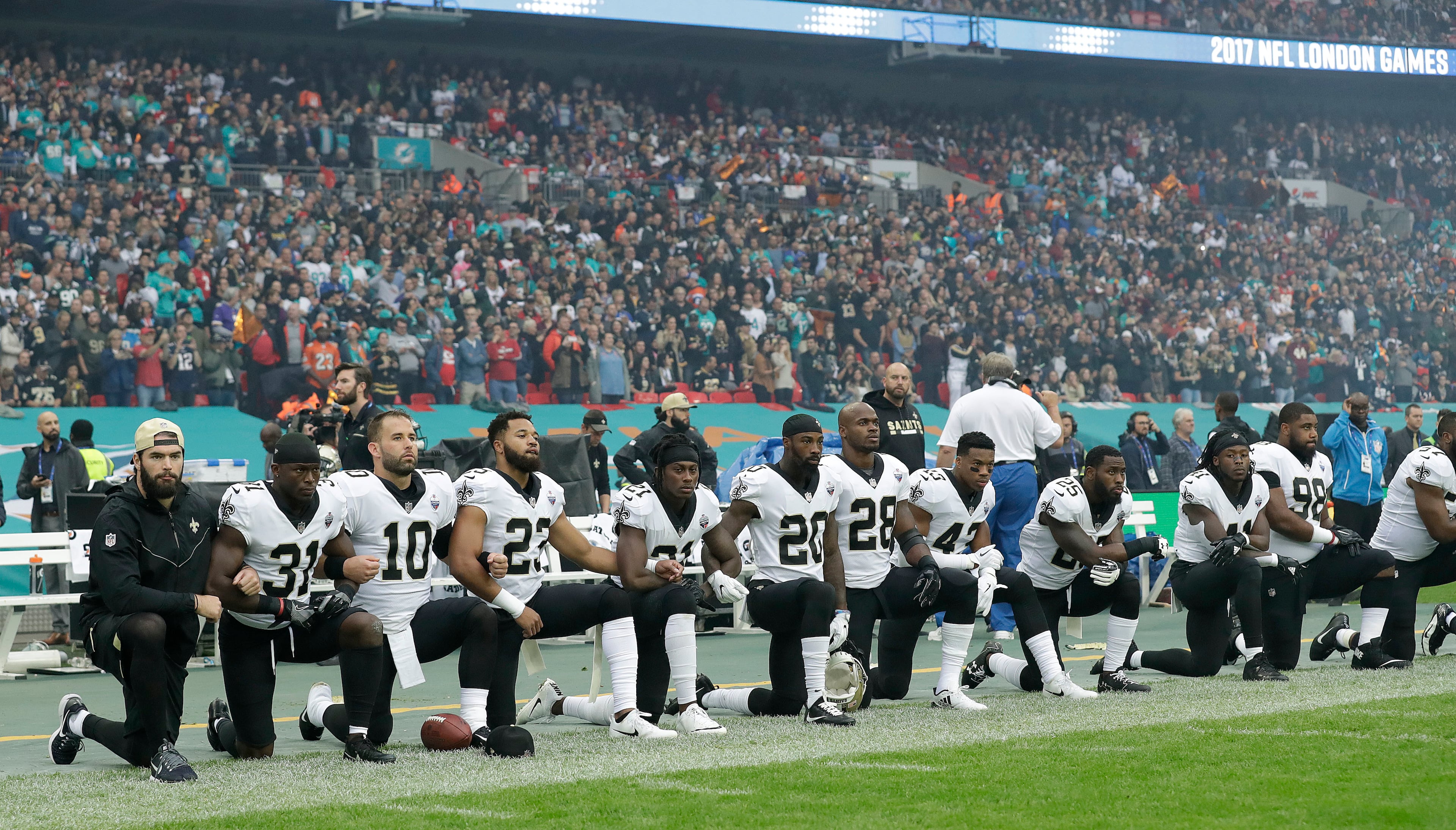 New Orleans Saints players kneel down before the U.S. anthem was played for an NFL football game against the Miami Dolphins at Wembley Stadium in London, Sunday Oct. 1, 2017. (AP Photo/Matt Dunham)