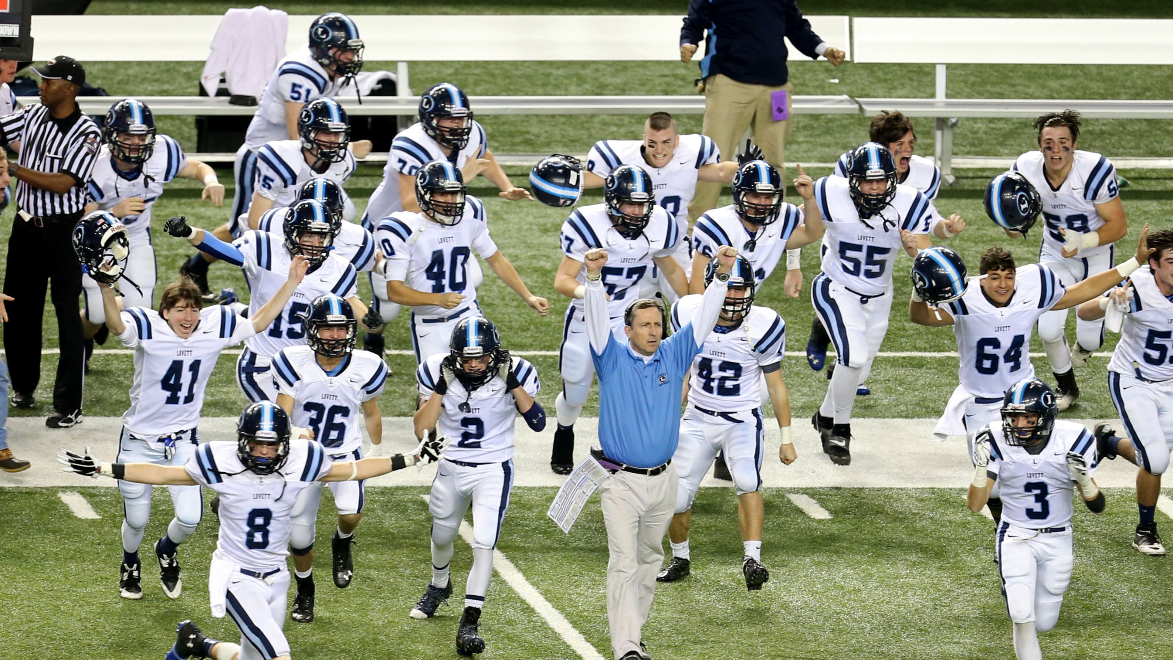 As time expires, Lovett coach Mike Muschamp, center, and players celebrate their 14-7 win over Lamar County at the Georgia Dome in Atlanta on Saturday, December 14, 2013.