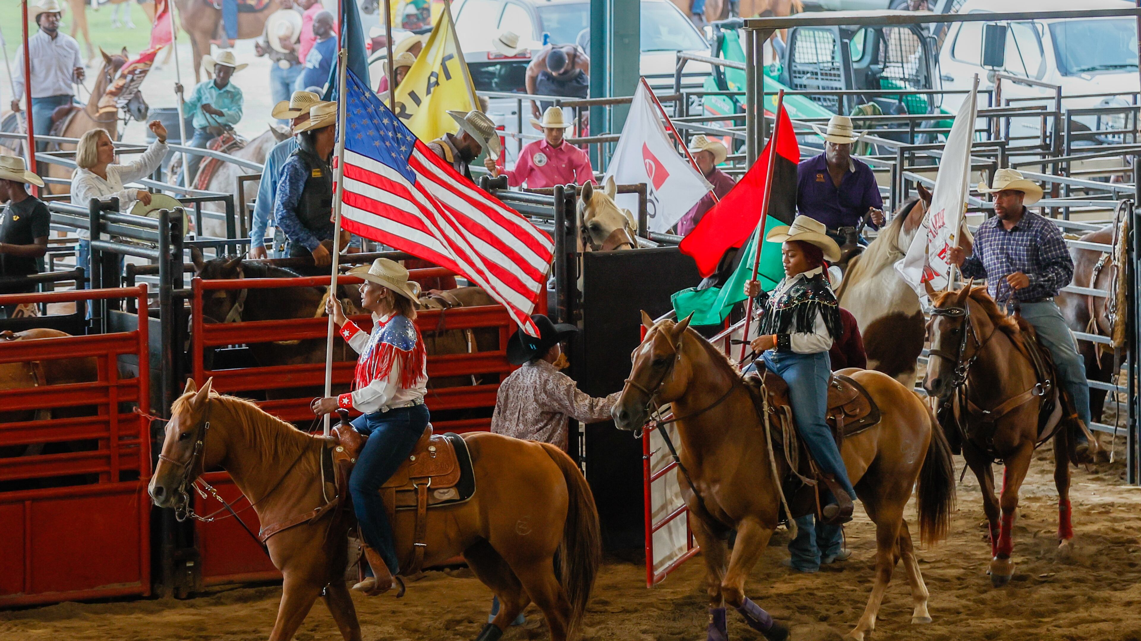 Participants carry flags as they head into the arena on horseback at the start of the Bill Pickett Rodeo at the Georgia International Horse Park in Conyers on Saturday, August 6, 2022. (Photo: Steve Schaefer / steve.schaefer@ajc.com)