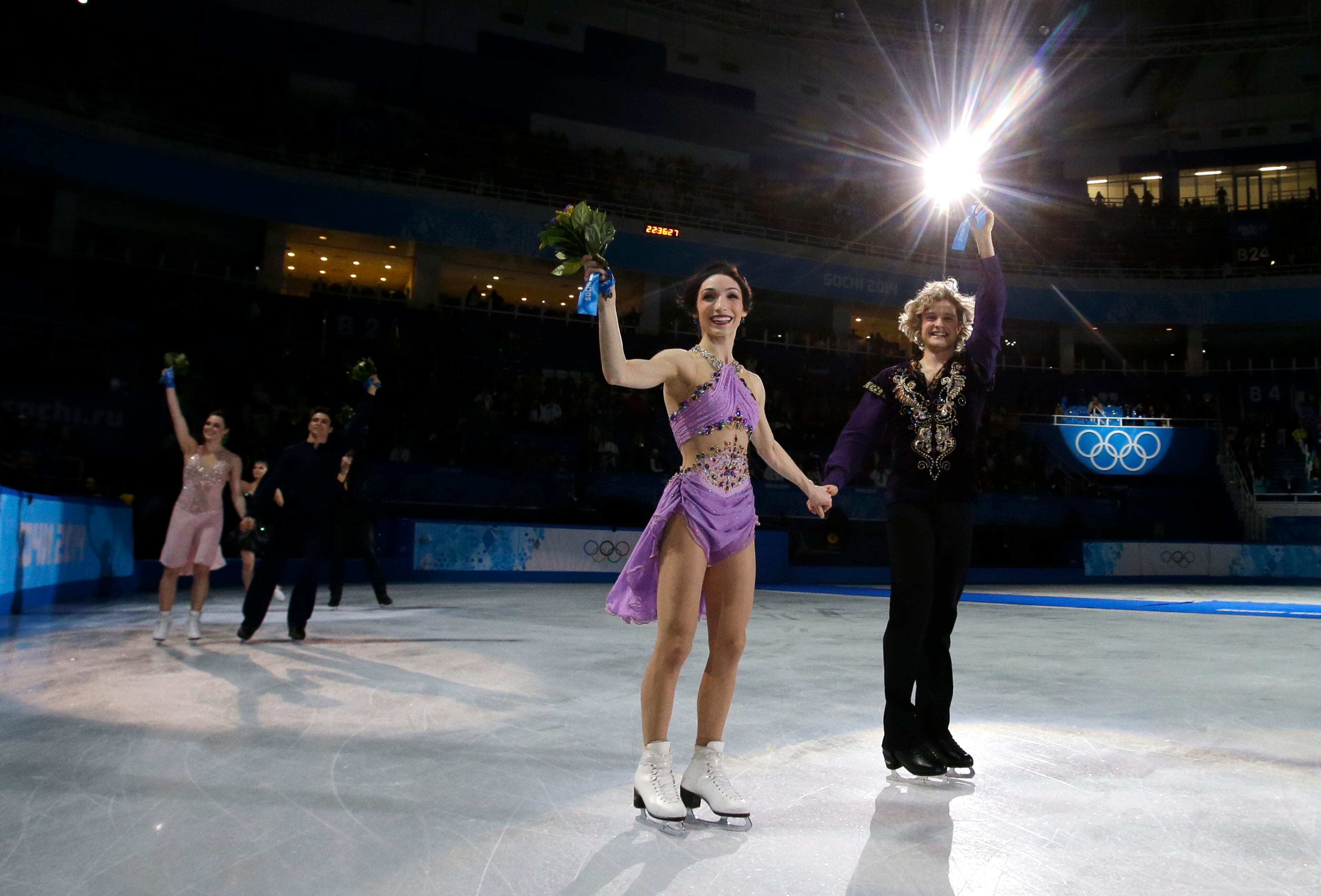 Meryl Davis and Charlie White of the United States celebrate their first place following the flower ceremony in the ice dance free dance figure skating finals at the Iceberg Skating Palace during the 2014 Winter Olympics, Monday, Feb. 17, 2014, in Sochi, Russia. (AP Photo/Darron Cummings)