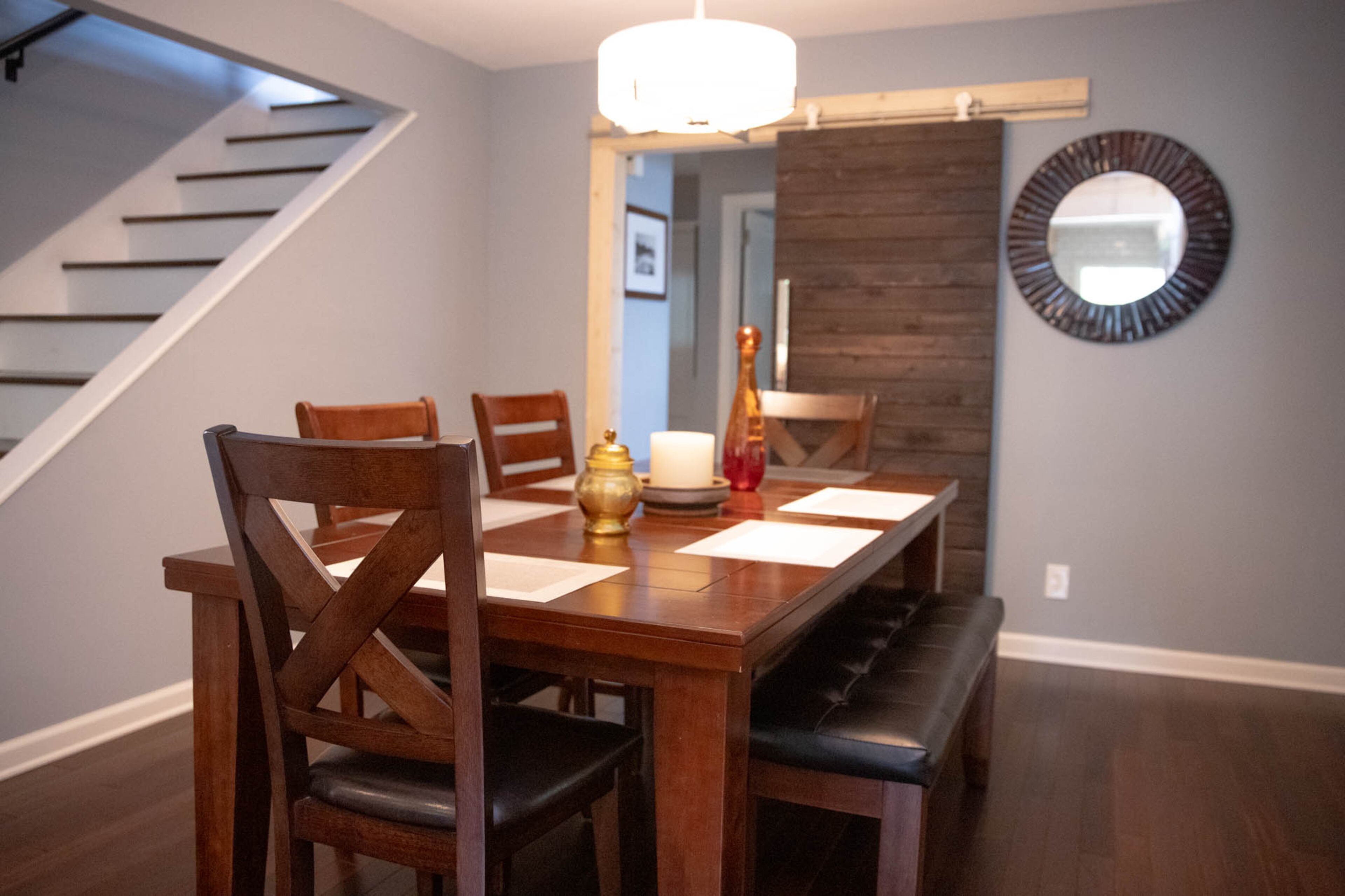 A table from Rooms To Go provides more seating in the dining room of Ben Ratossa and Adam Perry's Avondale Estates home. A custom barn door by Jessica Murphy of Her Cave Atlanta allows the guest rooms beyond the dining room to be enclosed for privacy. Text by Shannon Dominy/ Photos by Reynolds Rogers